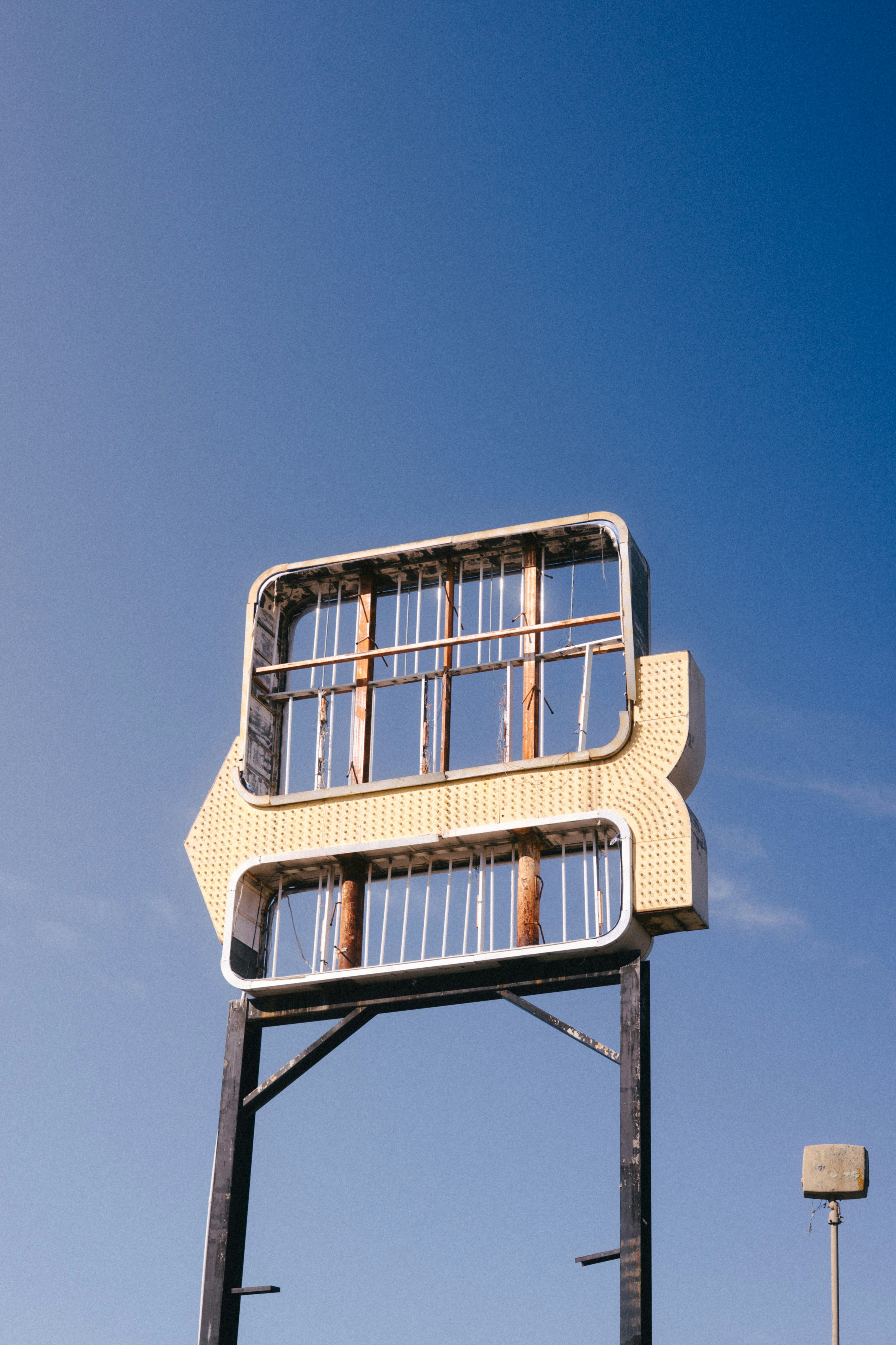 Placa abandonada à beira da estrada contra um céu azul claro