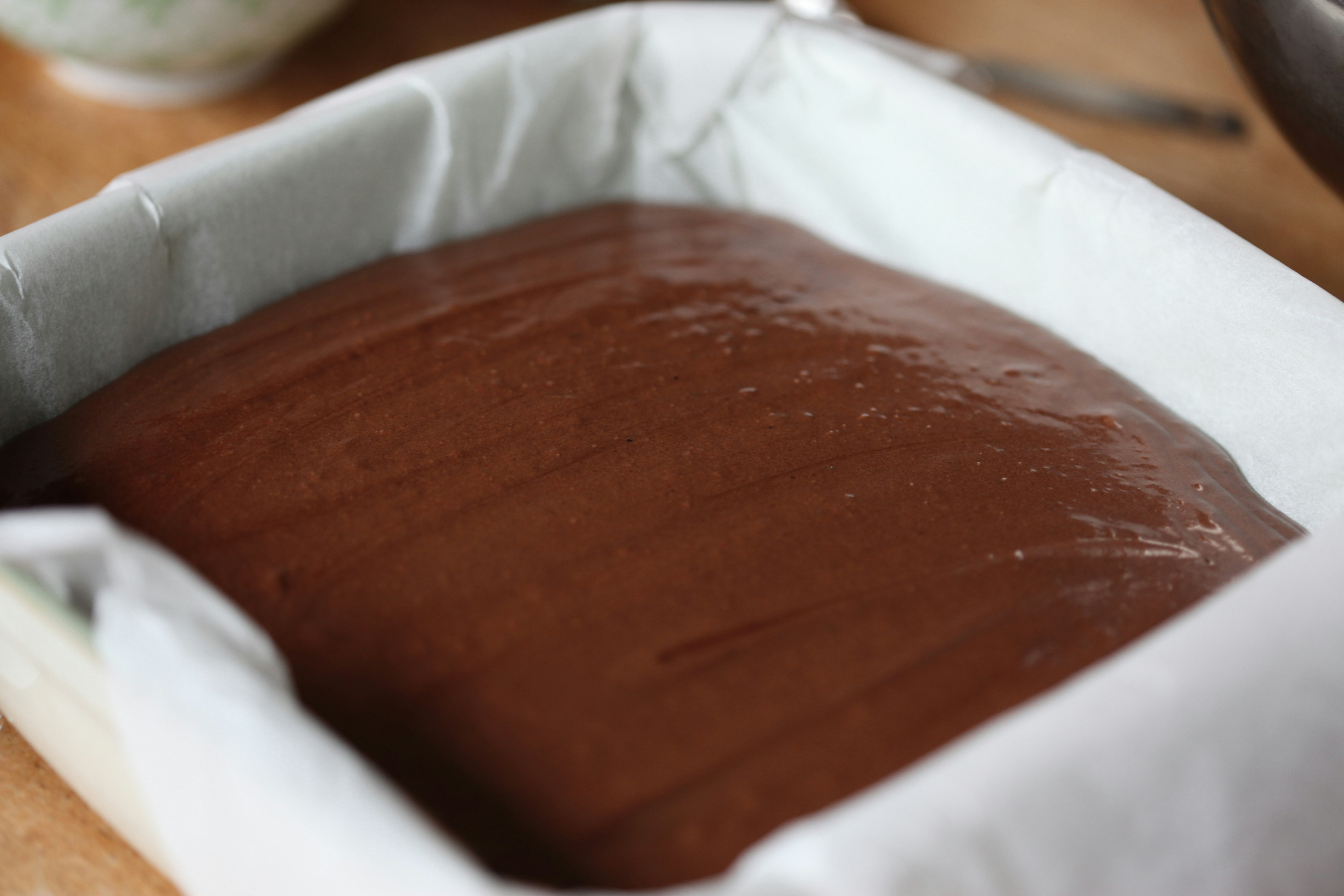 Chocolate batter smoothed in a baking pan.