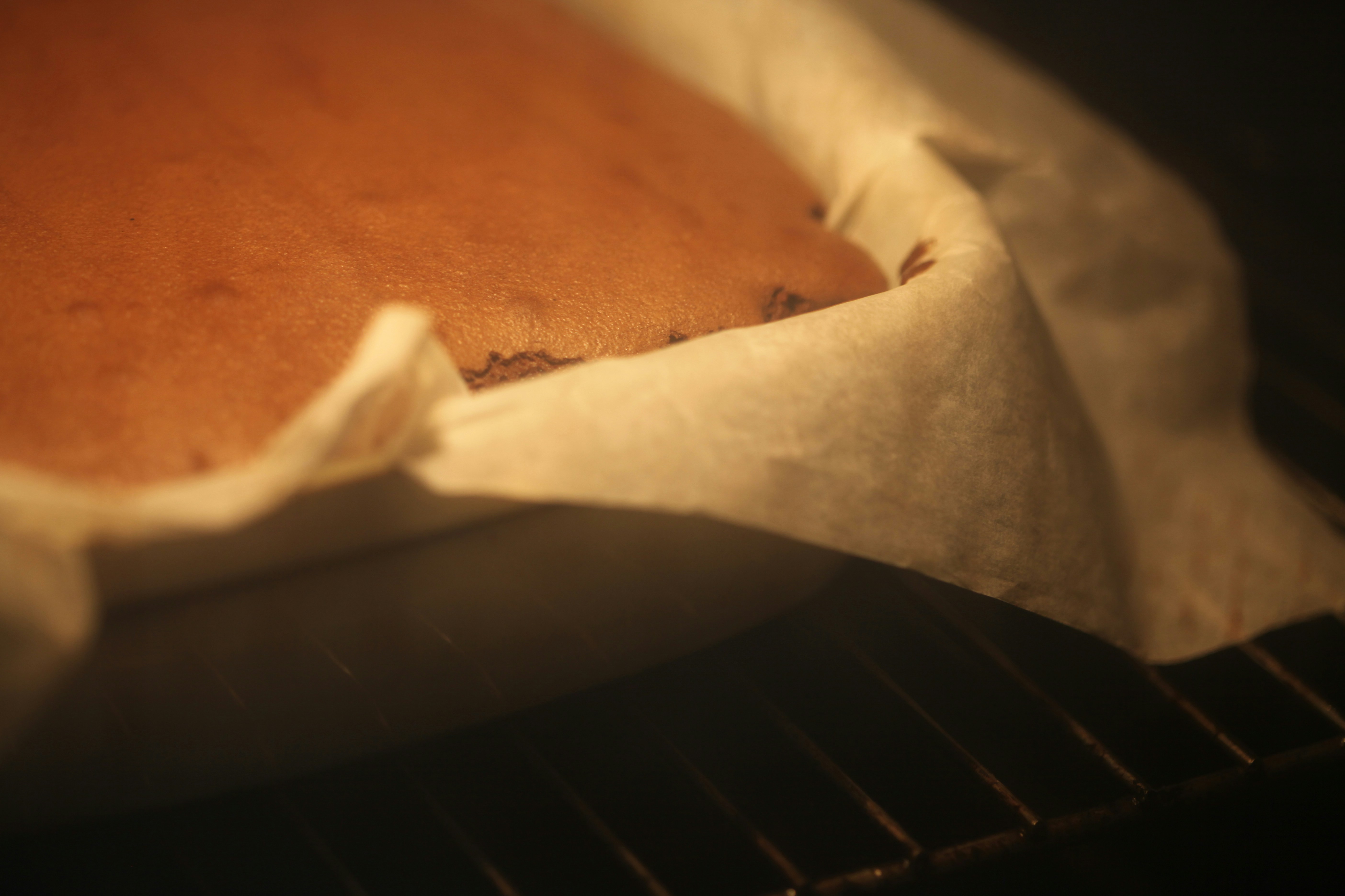 A cake baking in an oven on a rack.