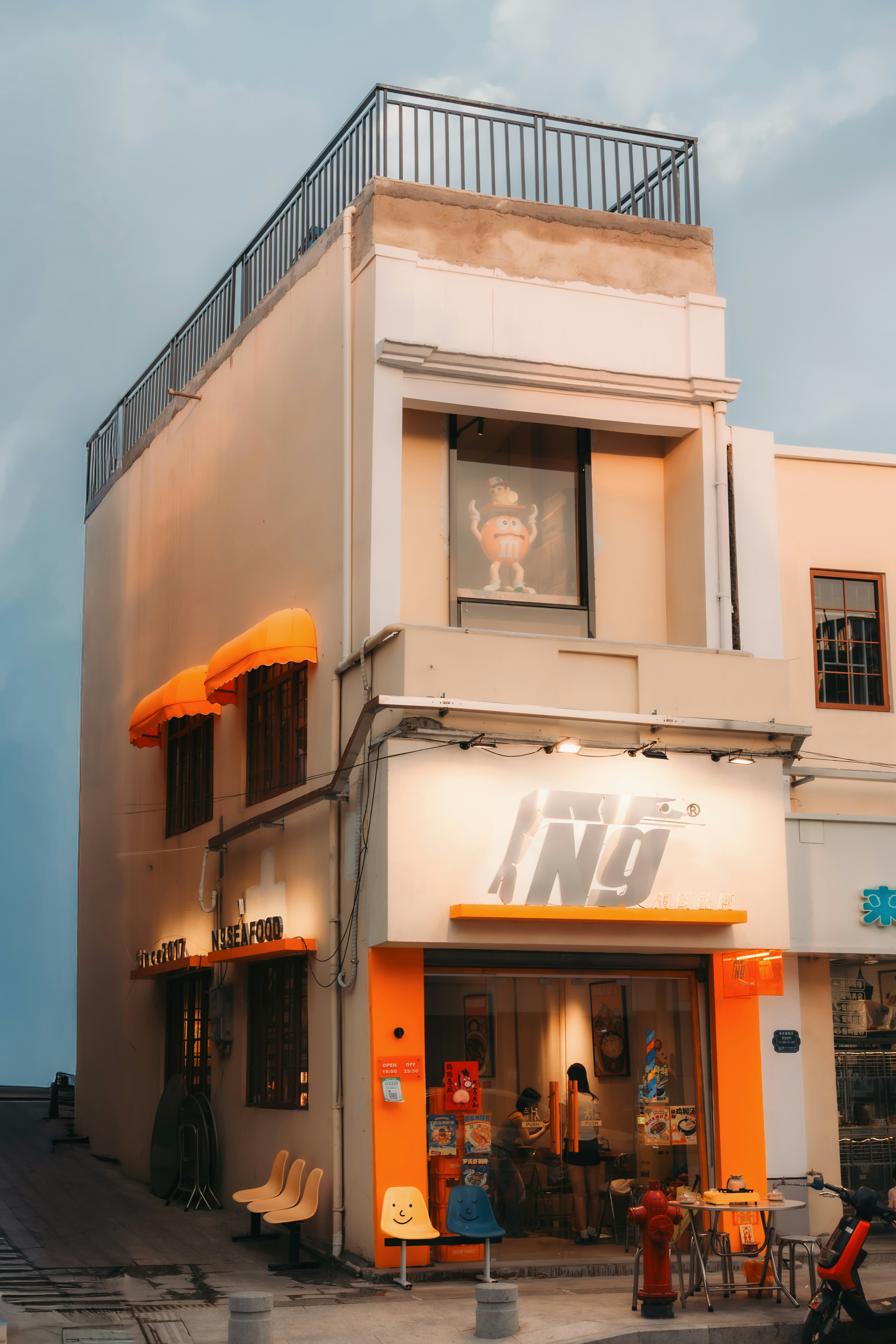A narrow building with orange awnings and signage.