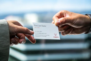 Two hands exchanging a business card