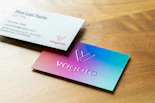 Two business cards on a wooden surface.