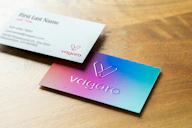 Two business cards on a wooden surface