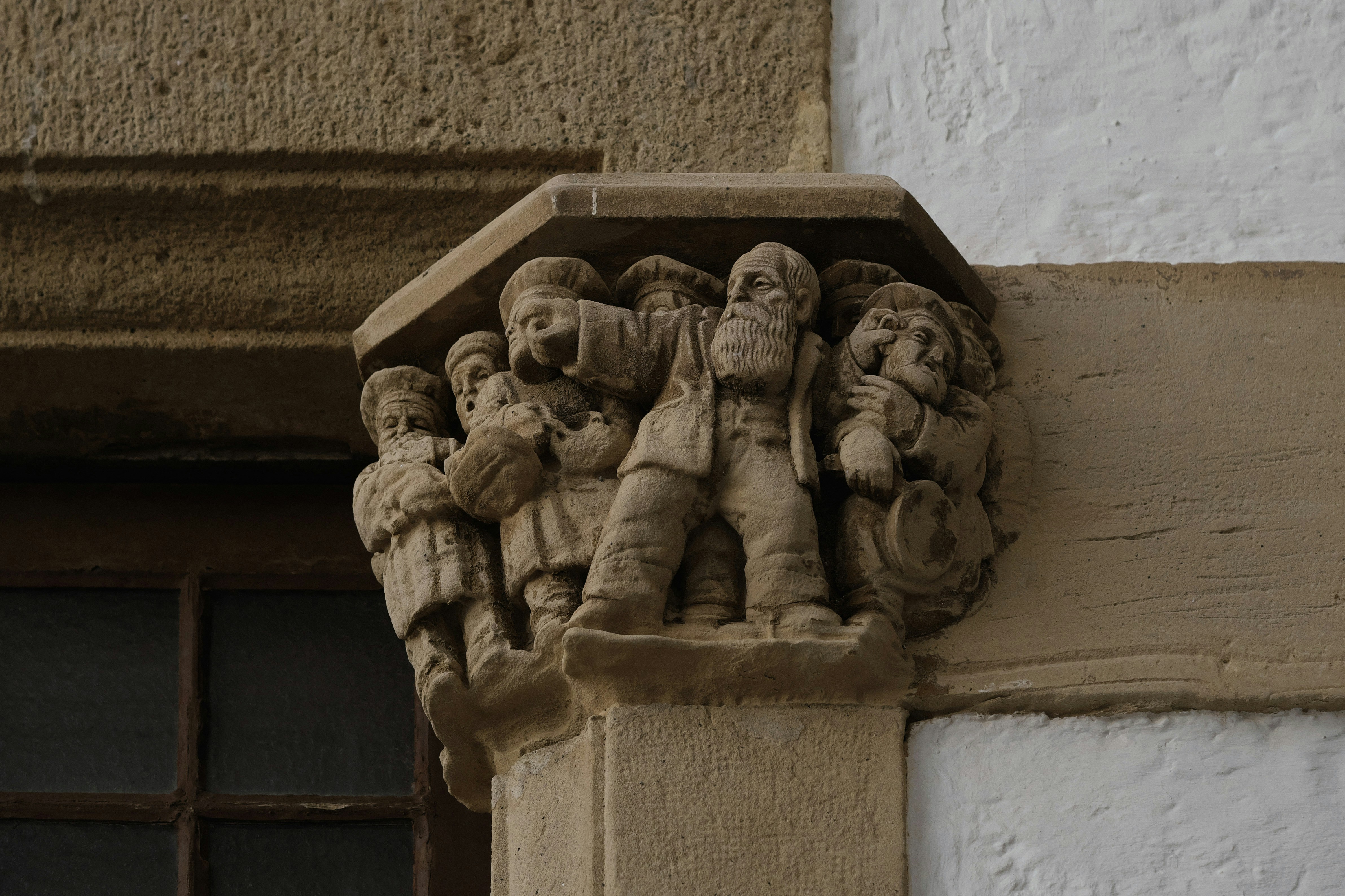 Escultura em pedra de figuras em um canto de prédio