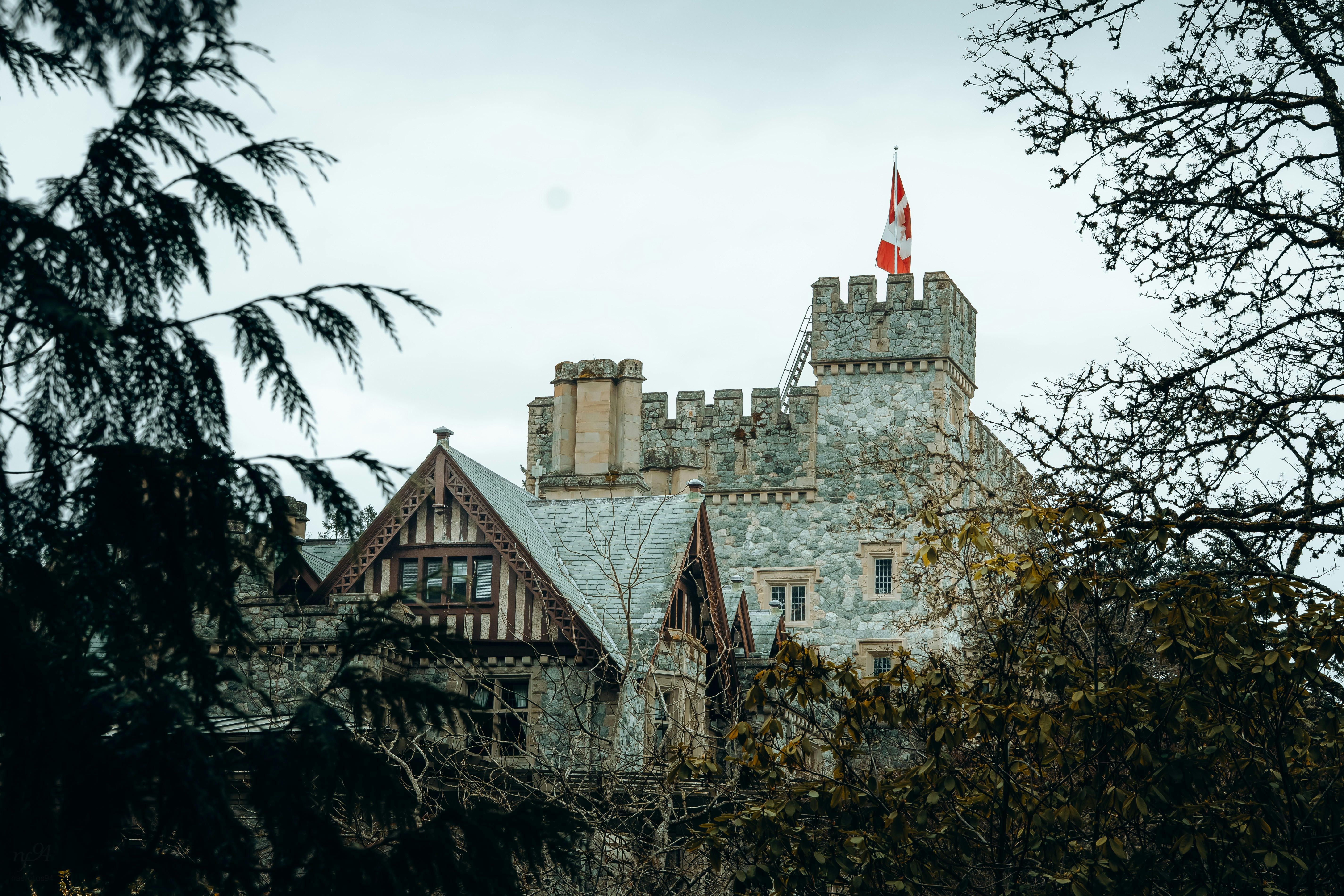 Stone castle with canadian flag under cloudy sky