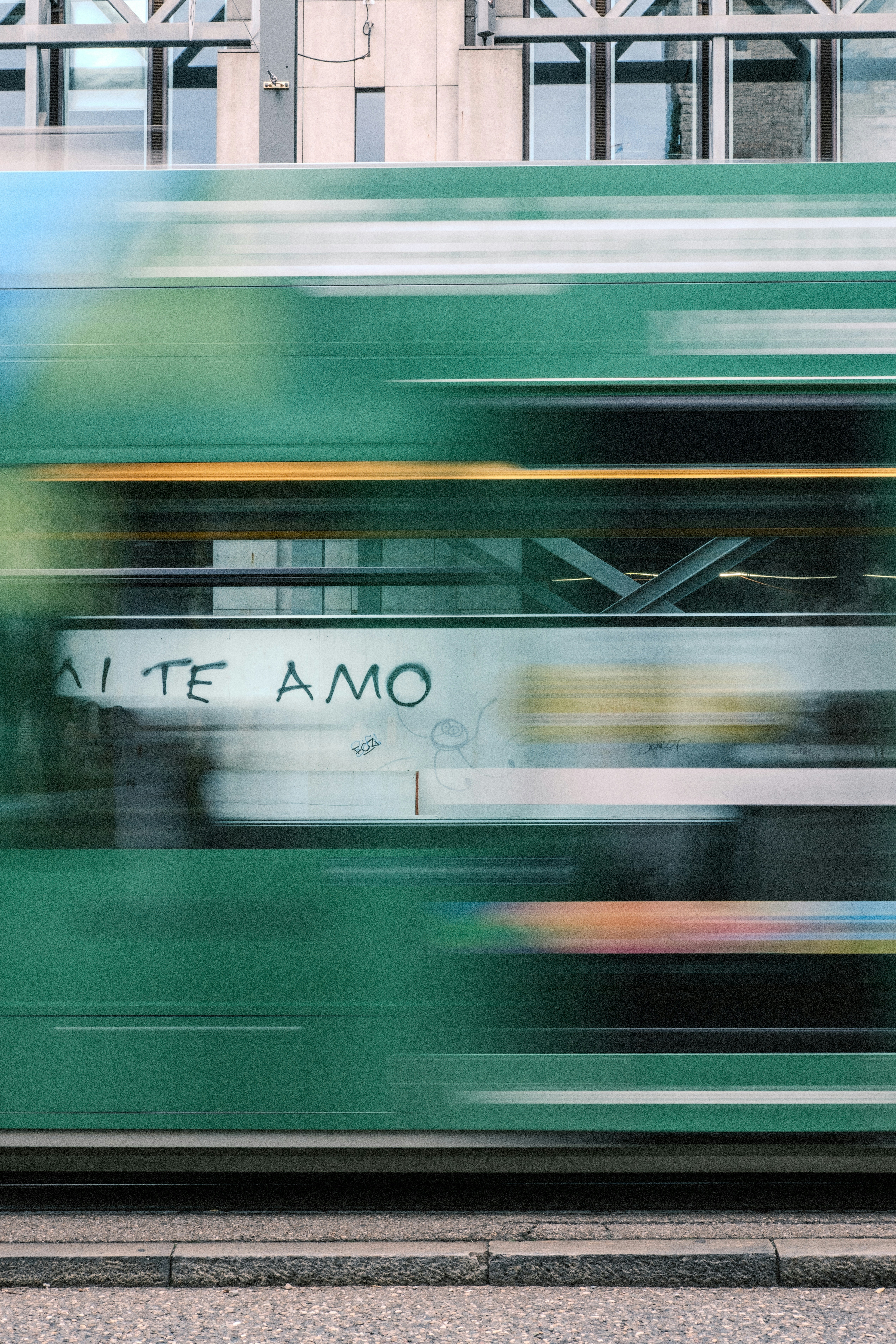 Grüne Straßenbahn mit "te amo"-Graffiti in Bewegung
