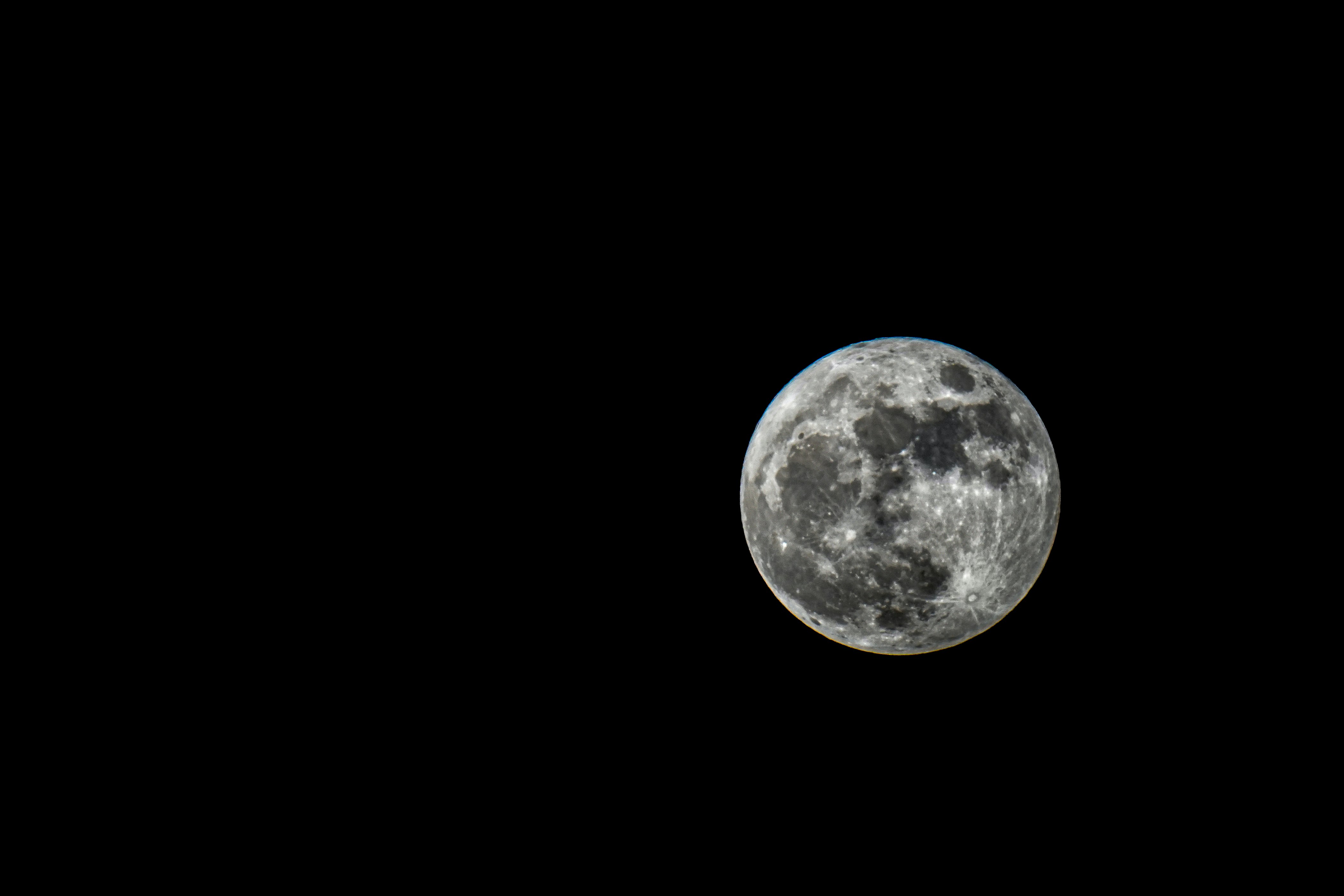 Full moon with visible craters in the dark night sky