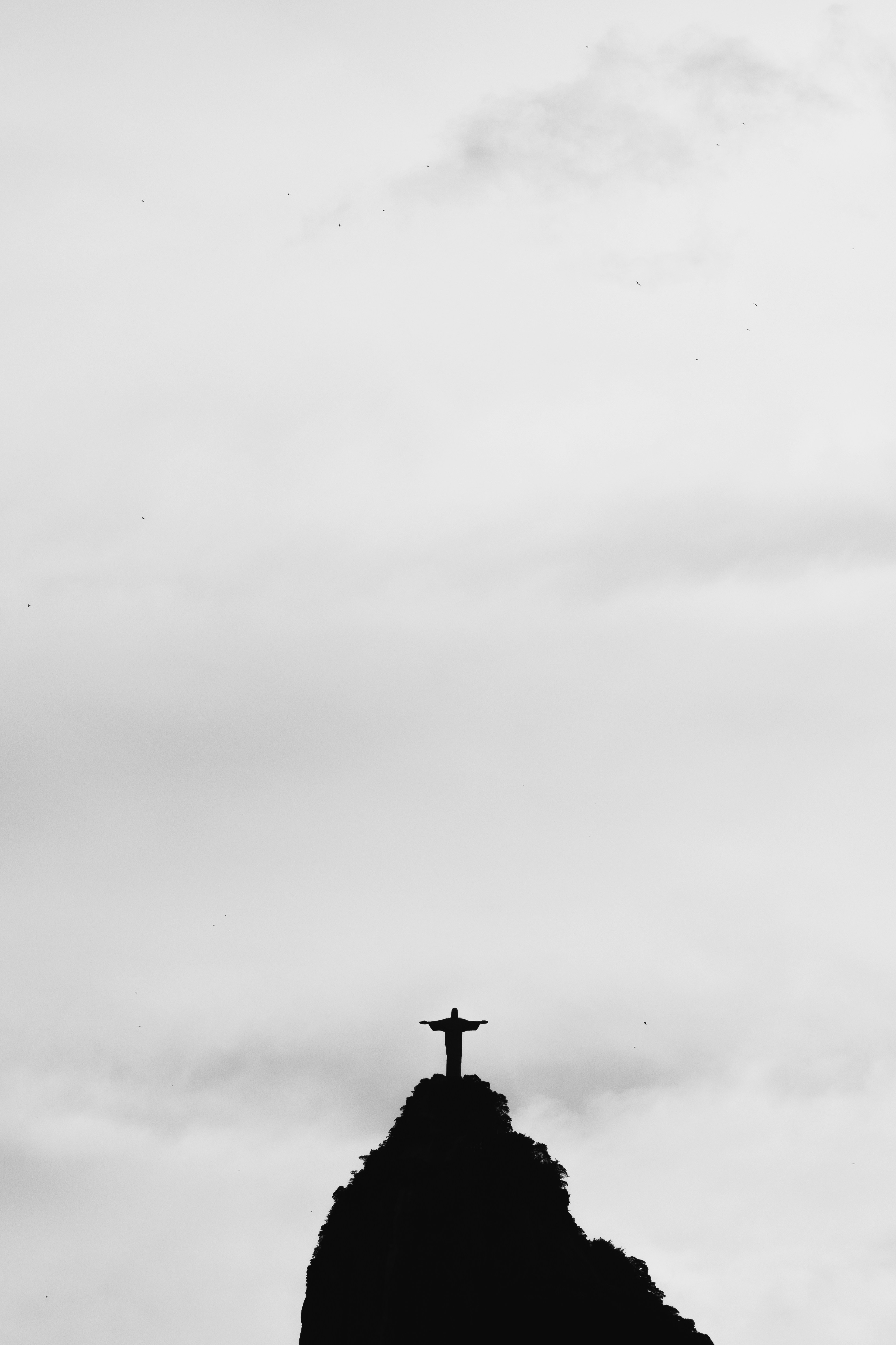 Silhouette of christ the redeemer statue against cloudy sky