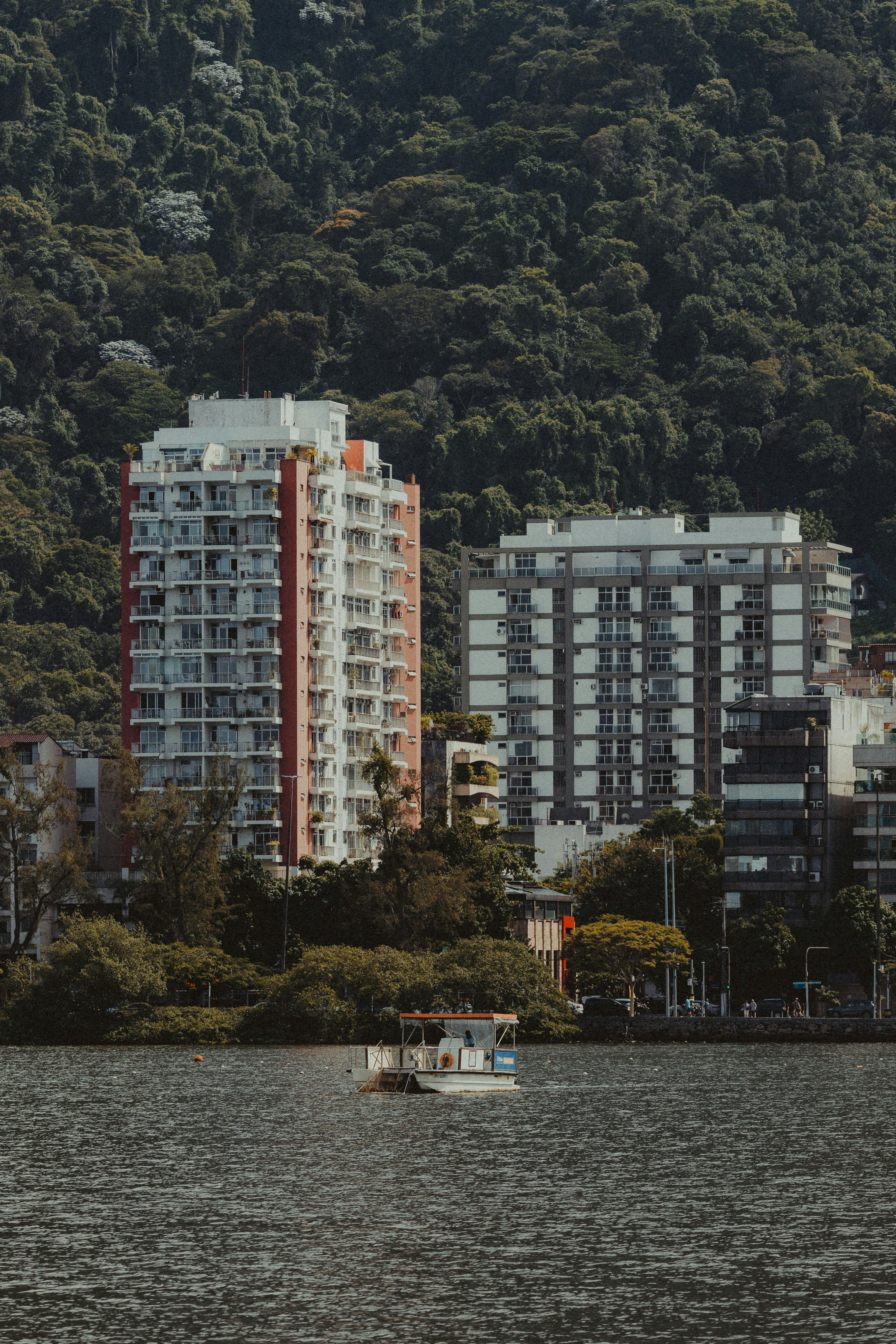 Two apartment buildings by a body of water.