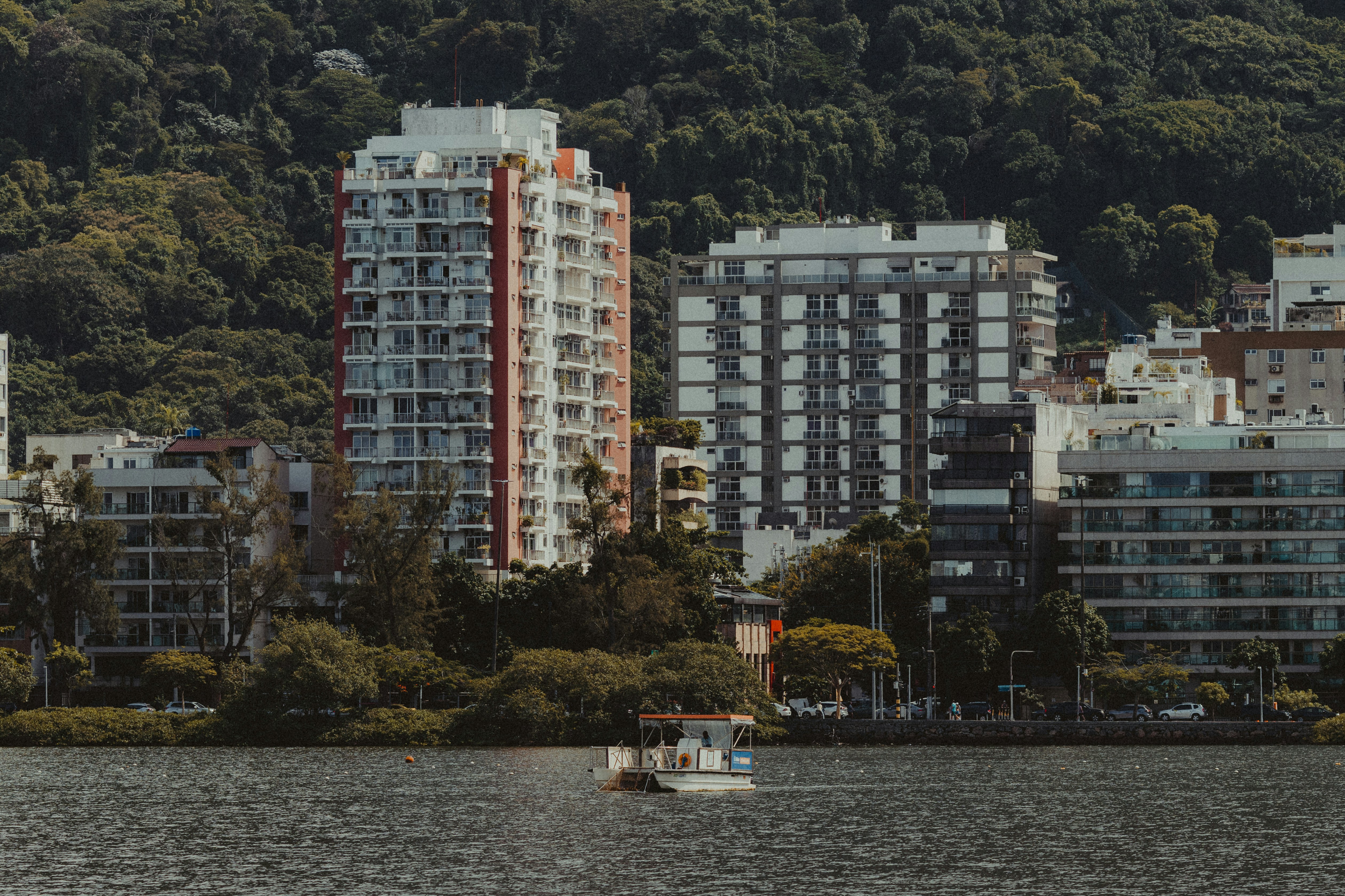 Apartment buildings by a lake with a small boat