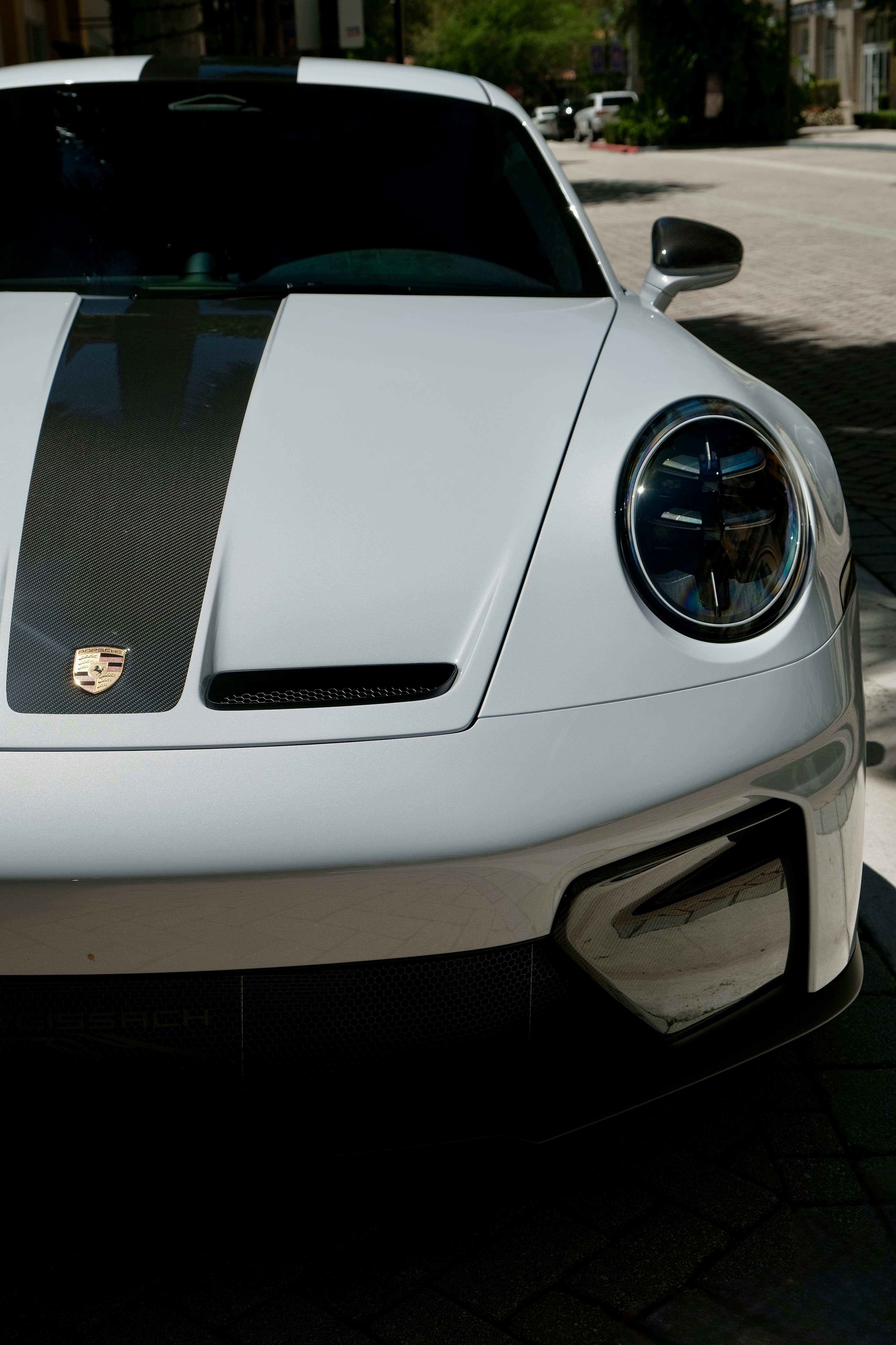 White sports car with black racing stripes