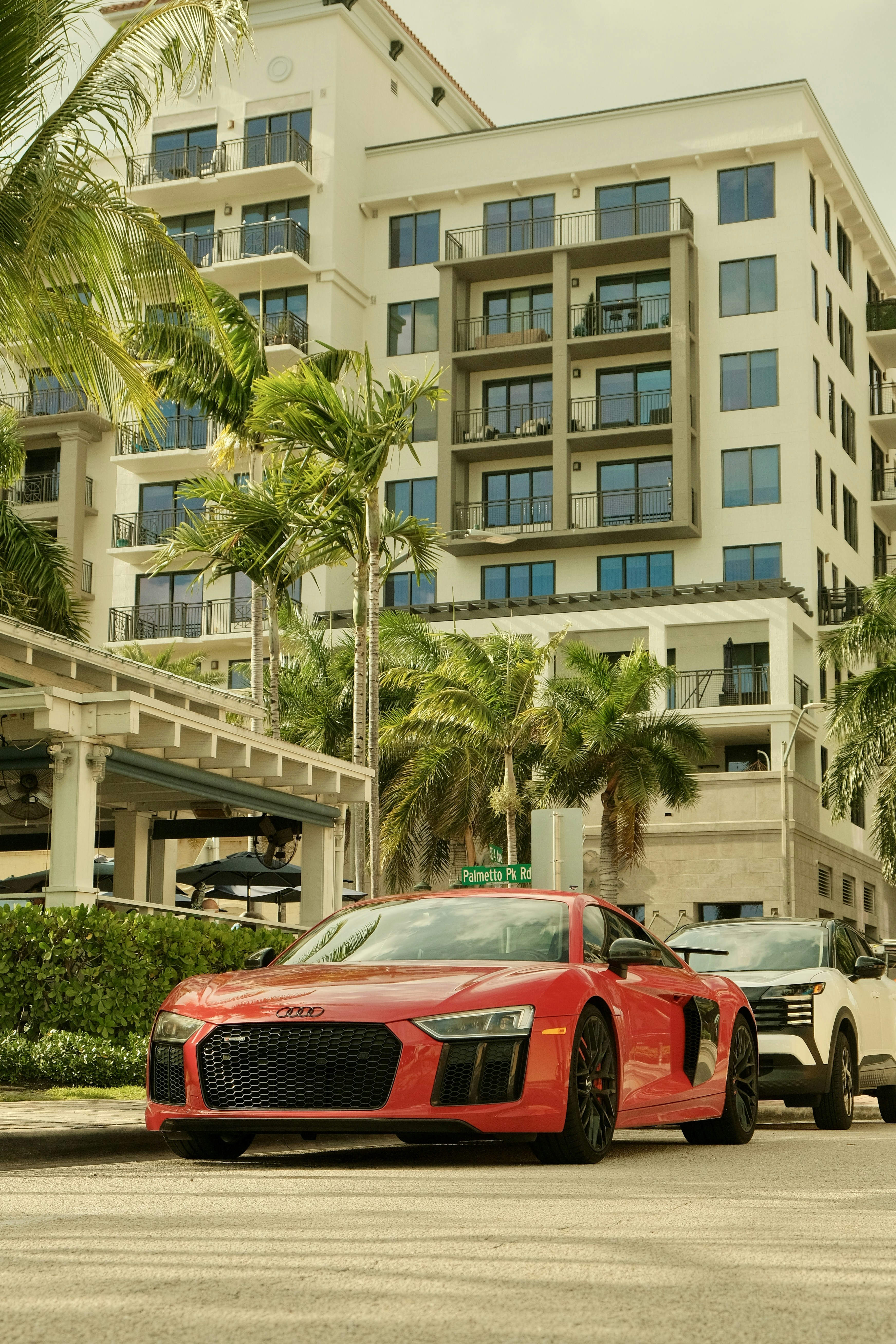 Red sports car parked on street with building.