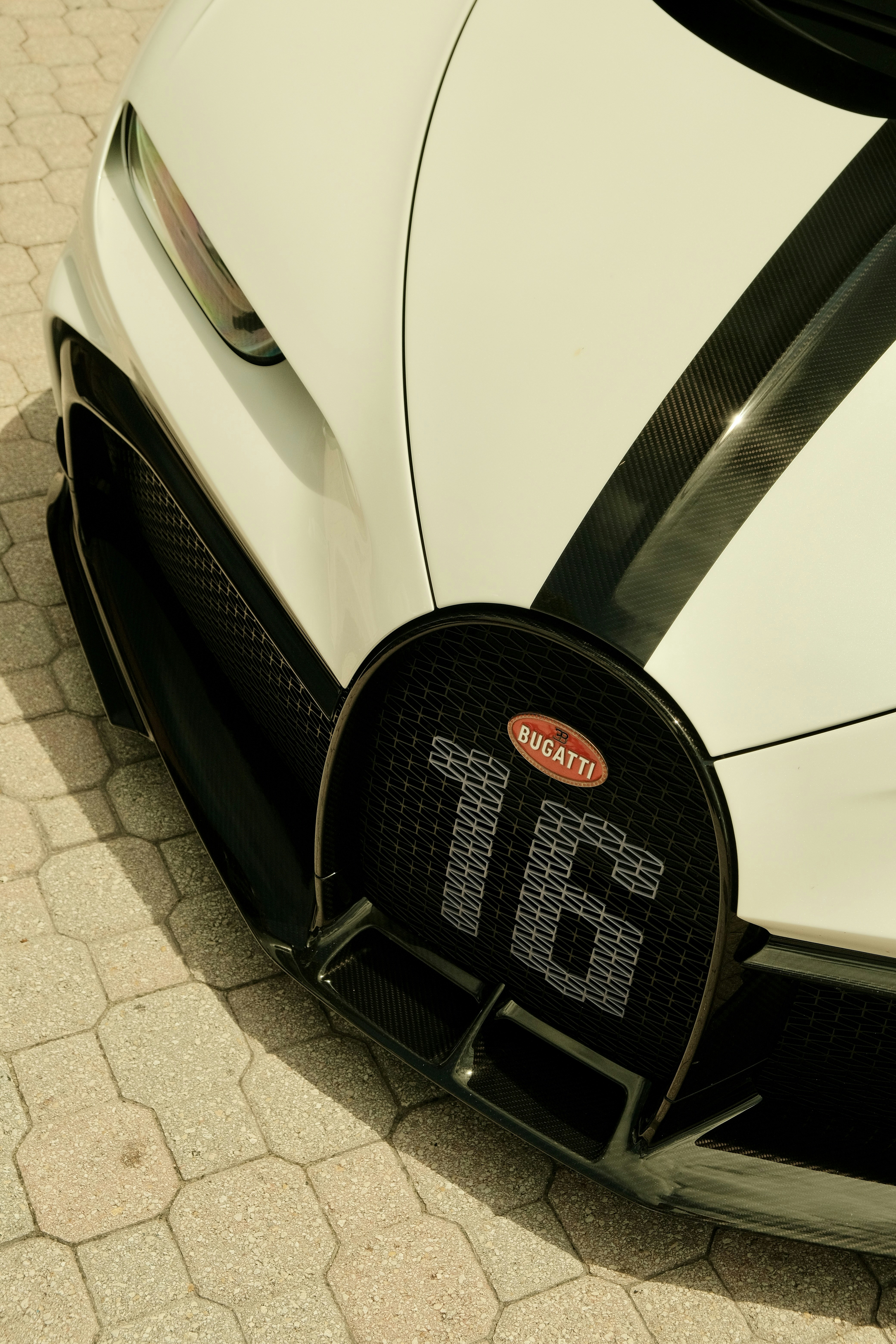White bugatti sports car with black racing stripes