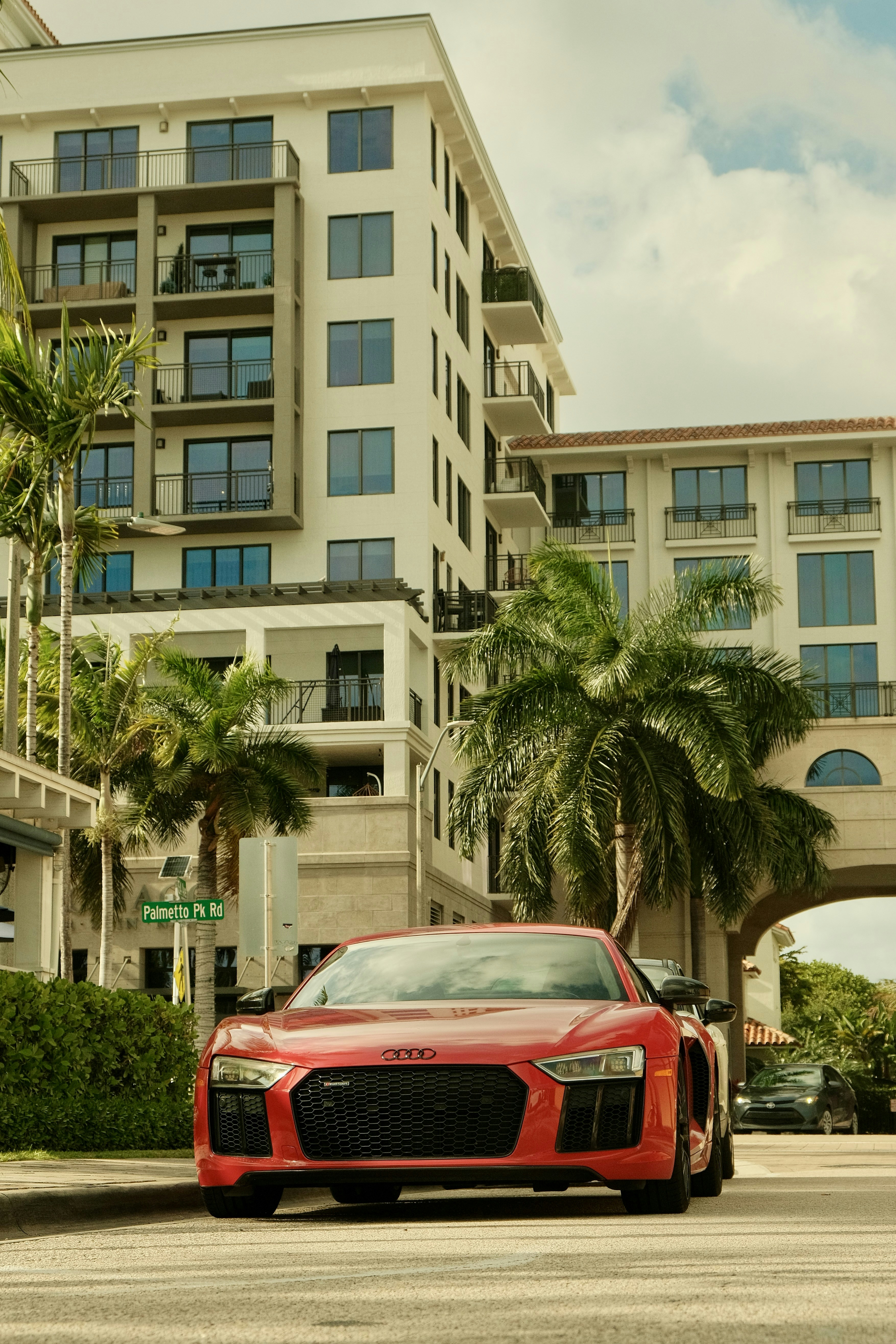 Red sports car parked on a street with buildings.