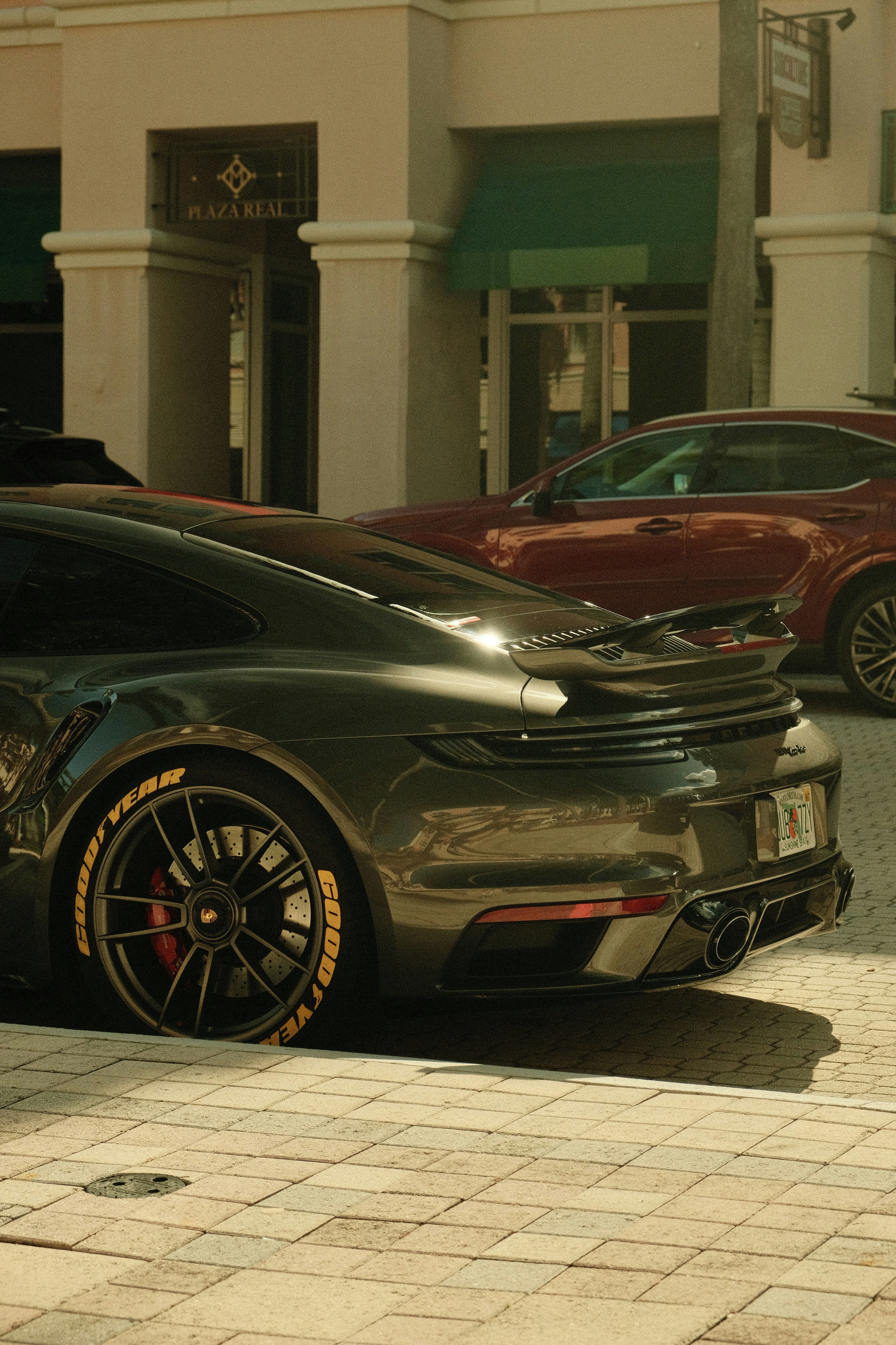 Dark grey sports car parked on a brick street - Free Photo on Unsplash