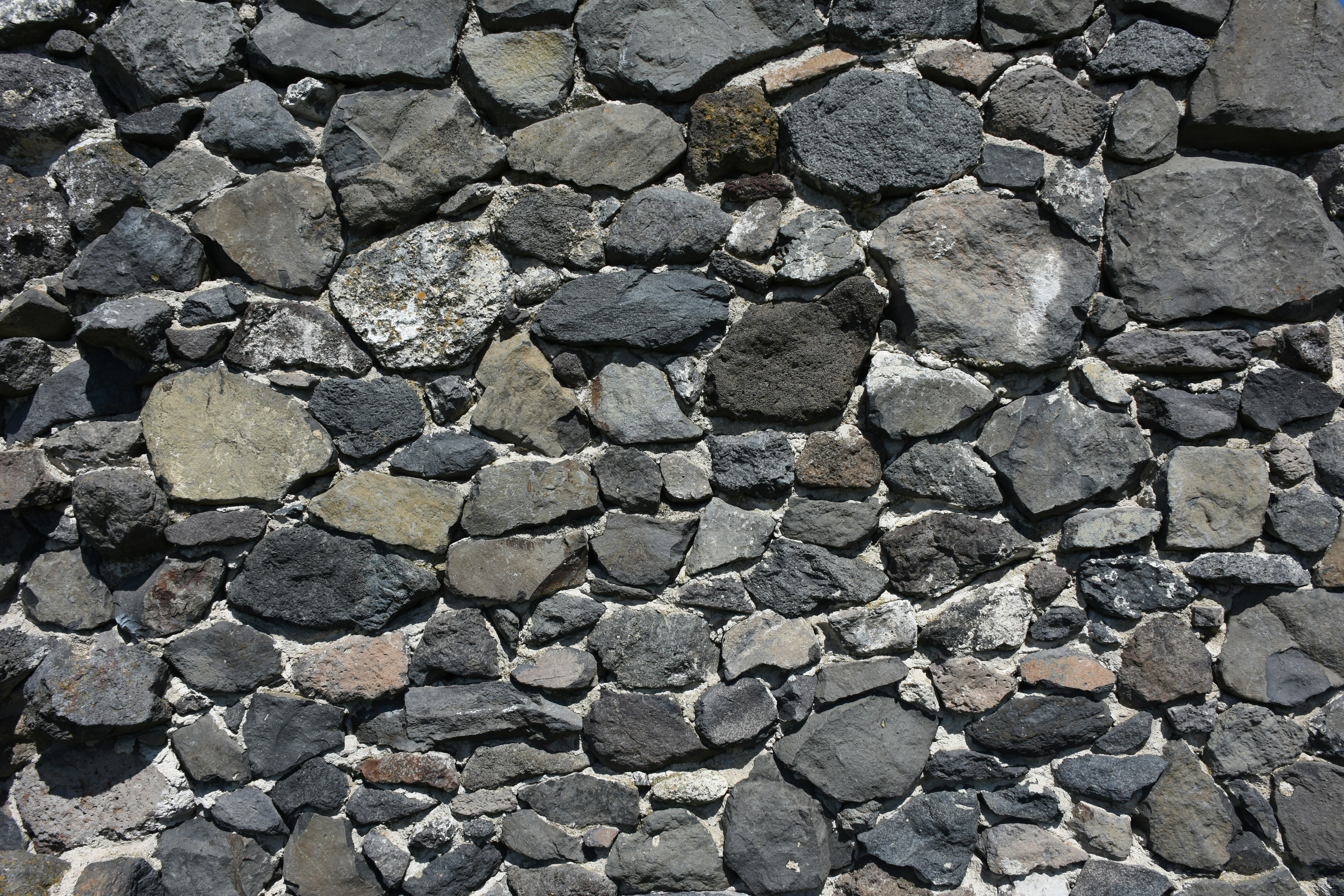 A wall constructed of various sized gray stones.