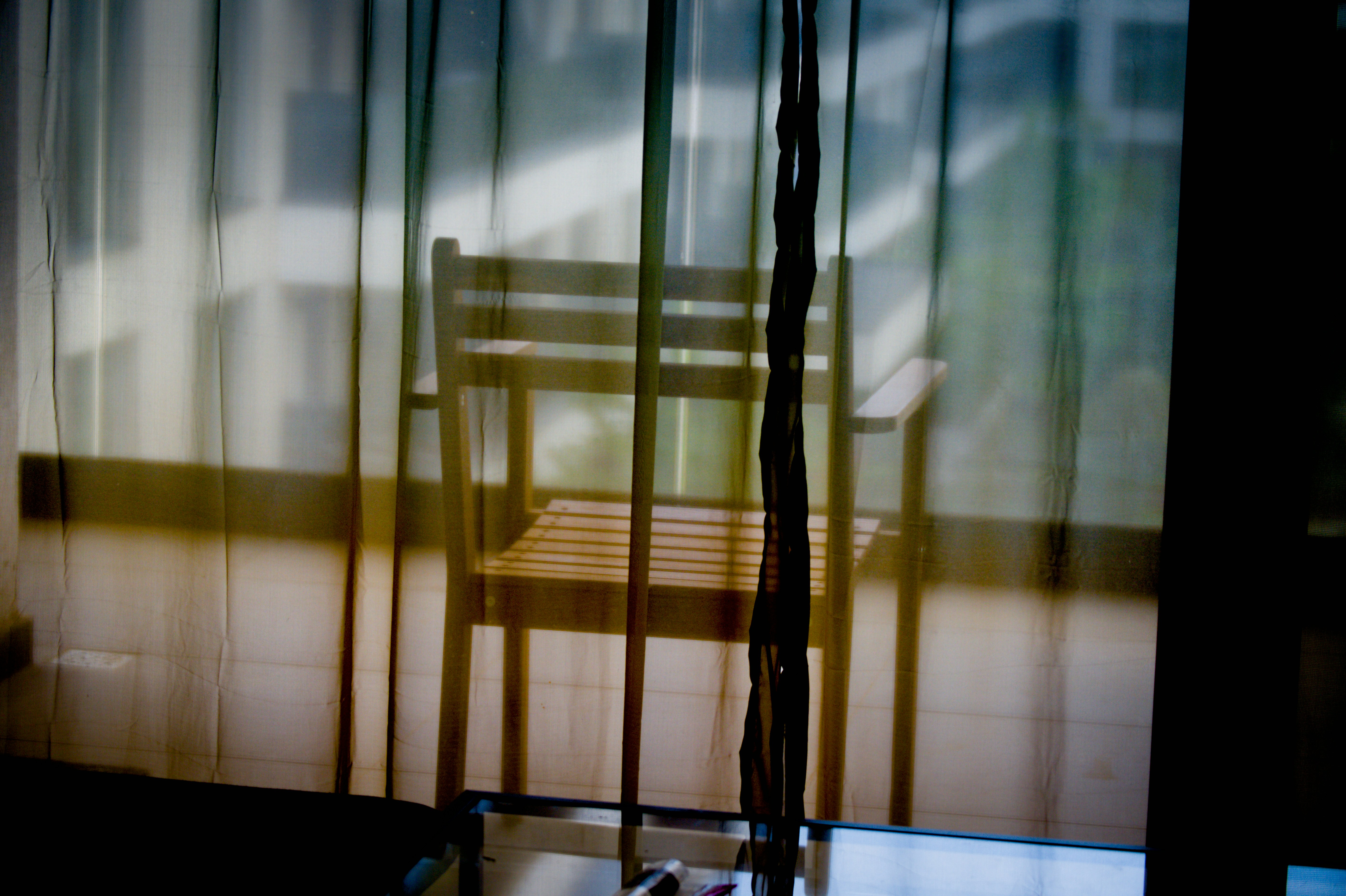 Chaise en bois vue à travers des rideaux transparents