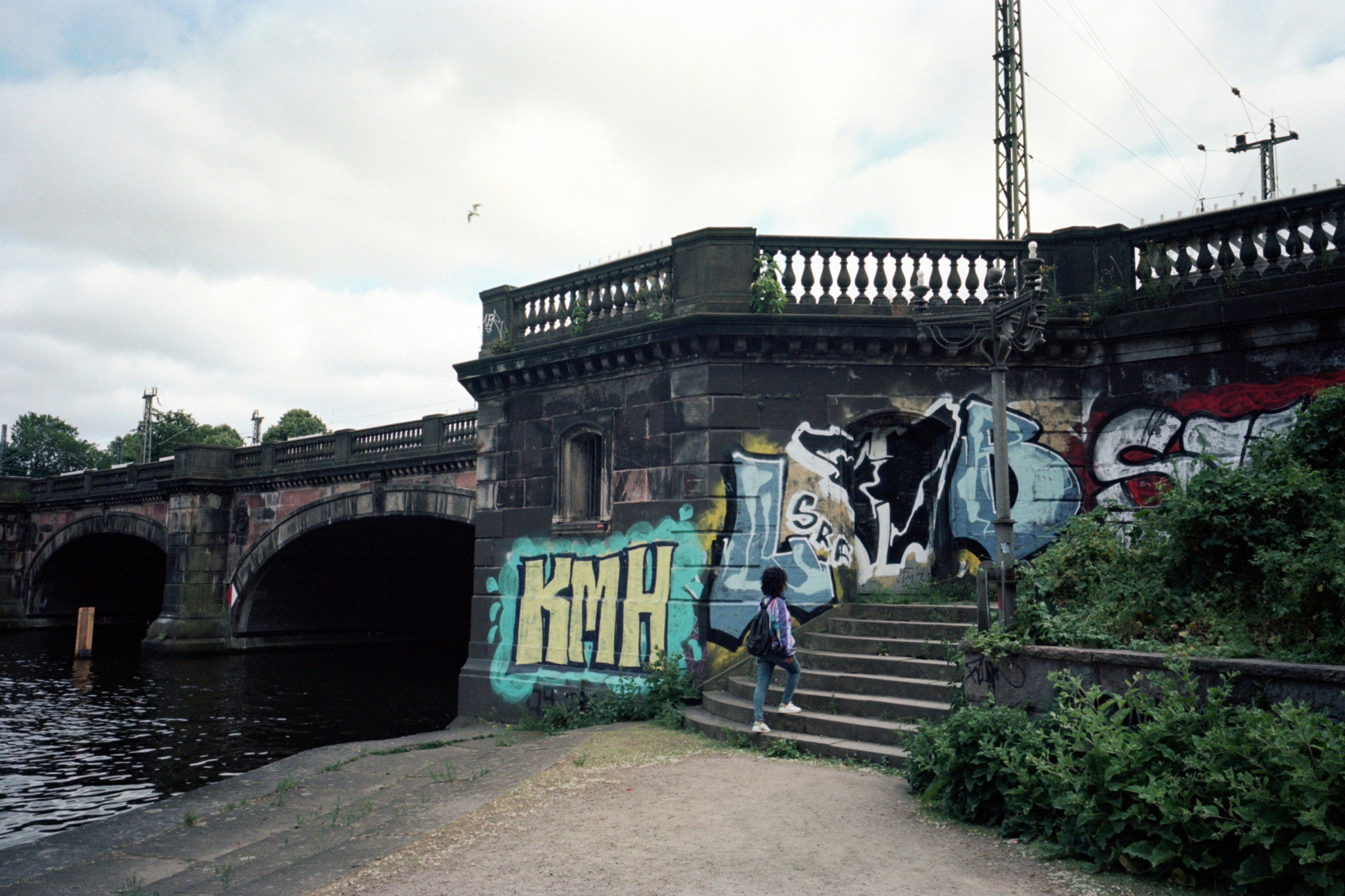 L'arte graffiti copre un ponte in pietra con aperture ad arco.