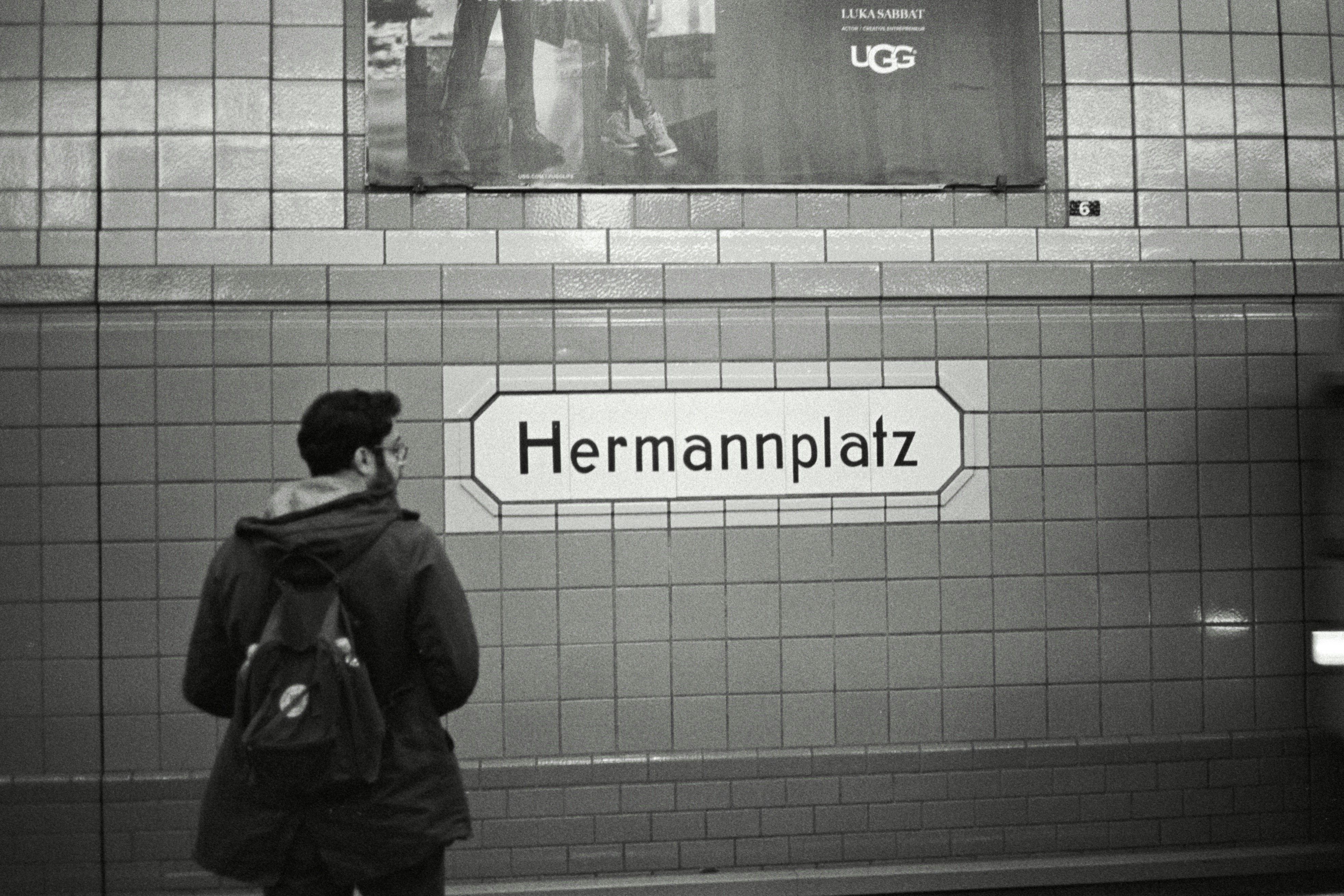 Uomo che guarda il cartello della stazione di Hermannplatz