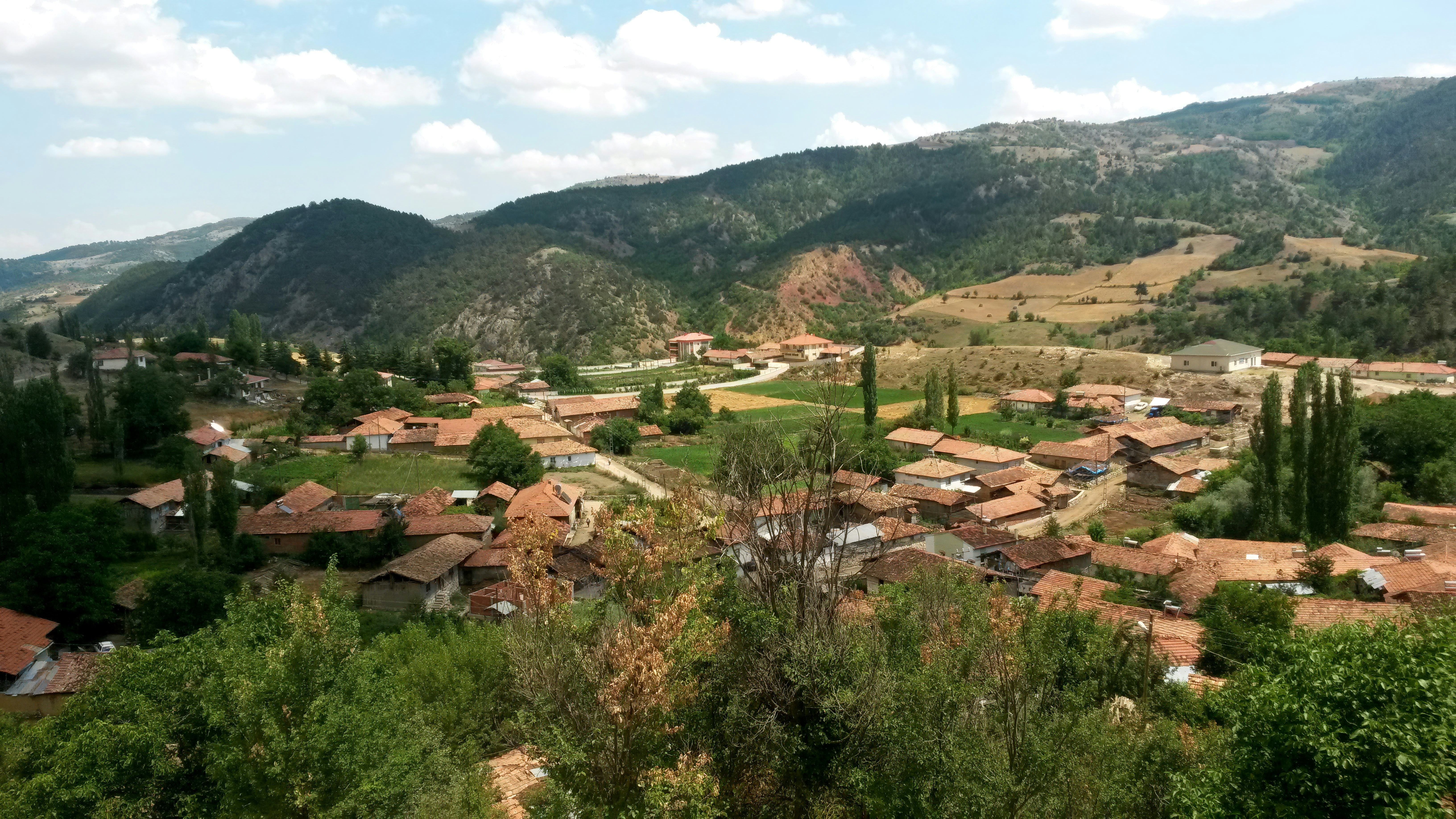 Villaggio rurale immerso in una valle con dolci colline.