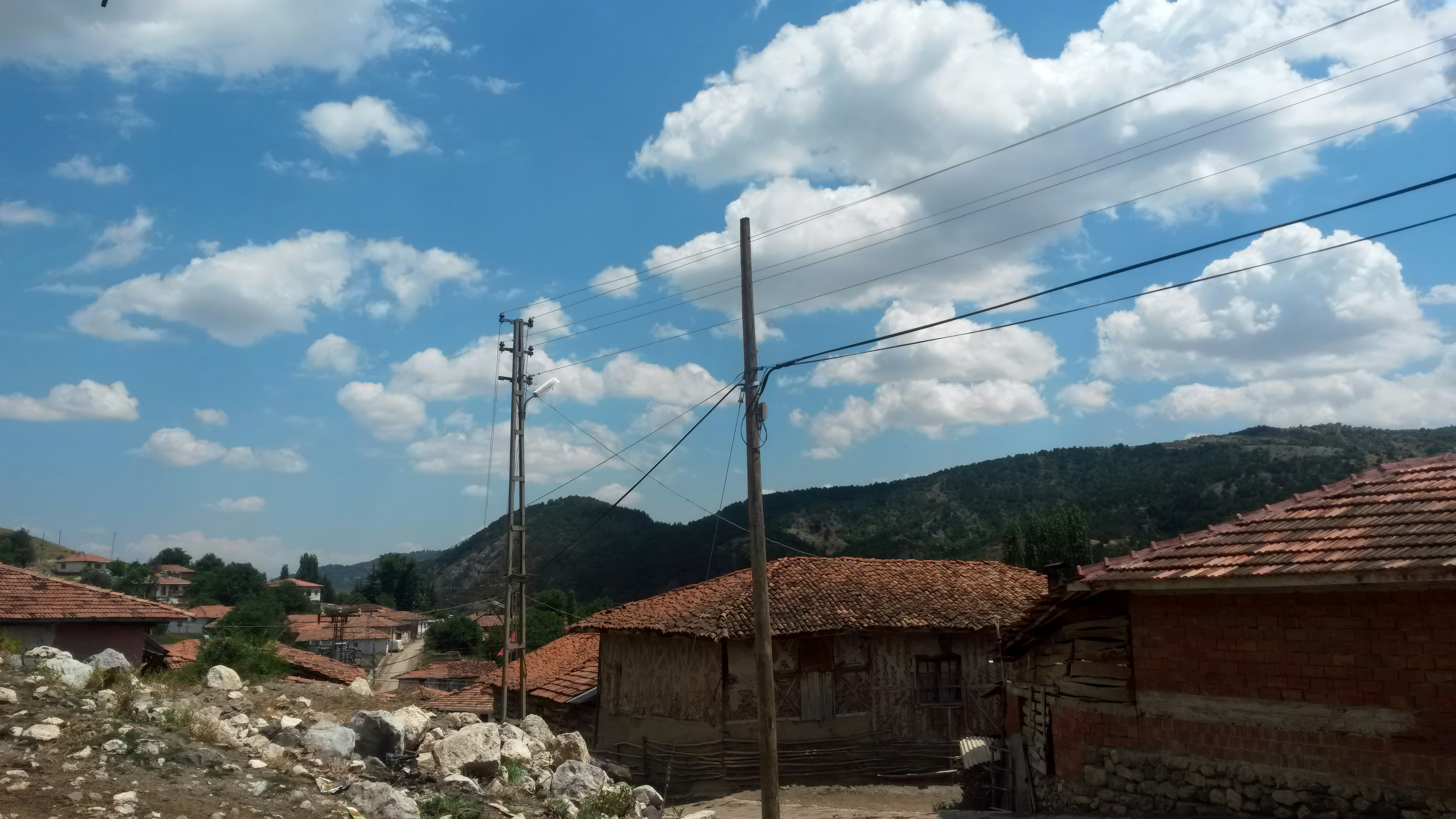Villaggio rurale con tetti tegolati sotto un cielo nuvoloso