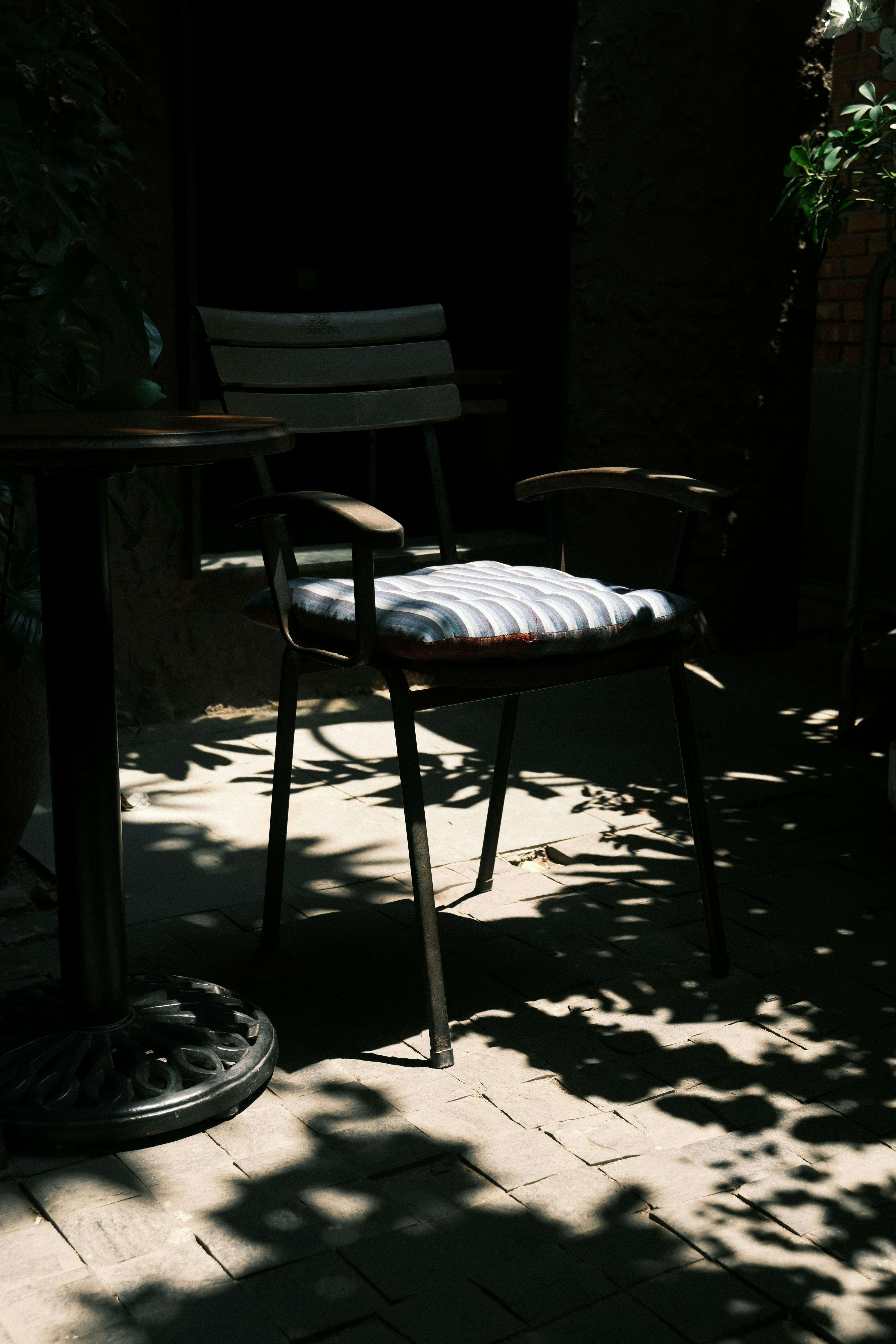 Cadeira e mesa vazias sob a luz do sol salpicada