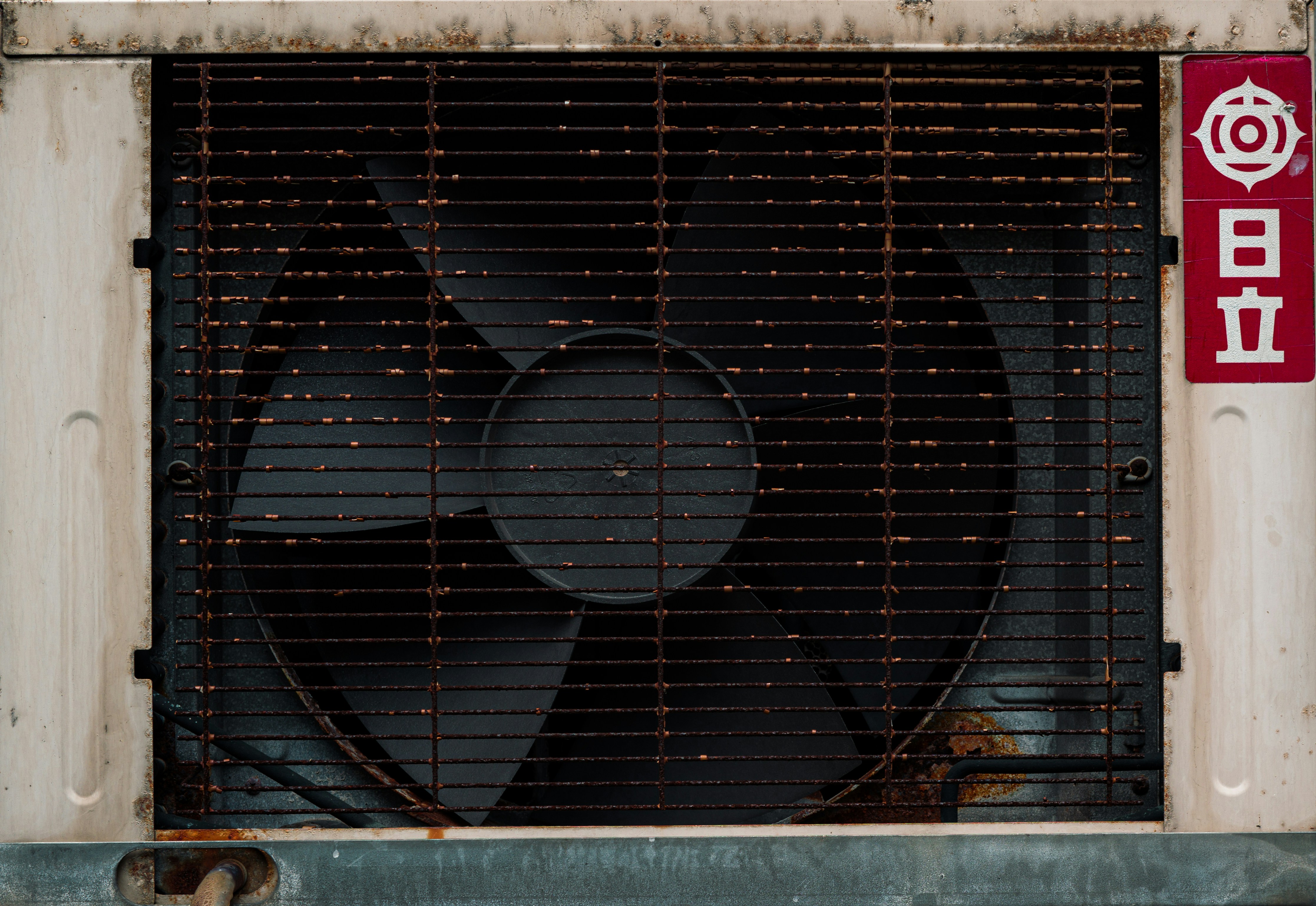 technician cleaning outdoor condenser coils with specialized brush