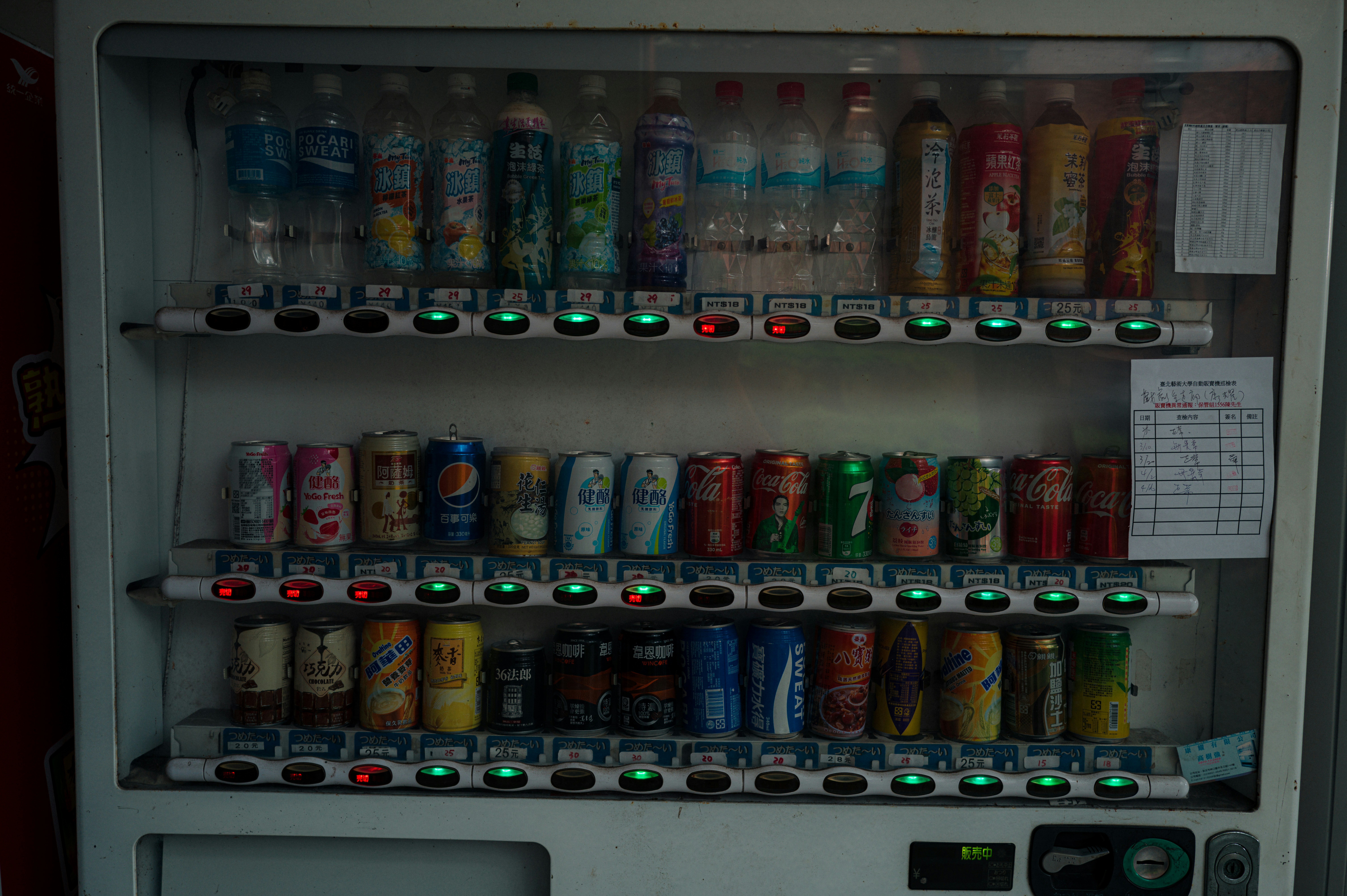 Máquina de venda automática cheia de bebidas e latas variadas.