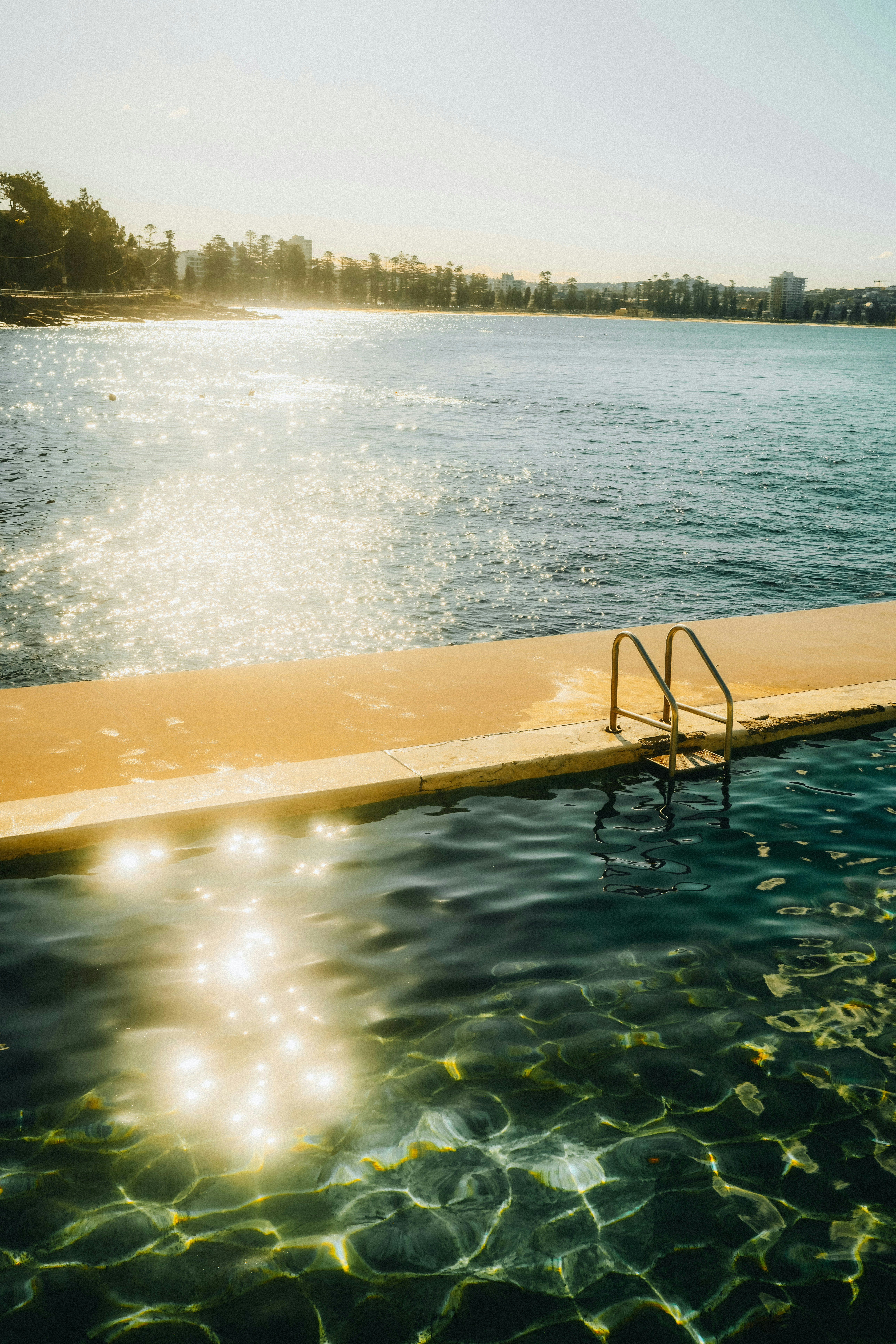 Ocean pool with ladder and shimmering sunlight