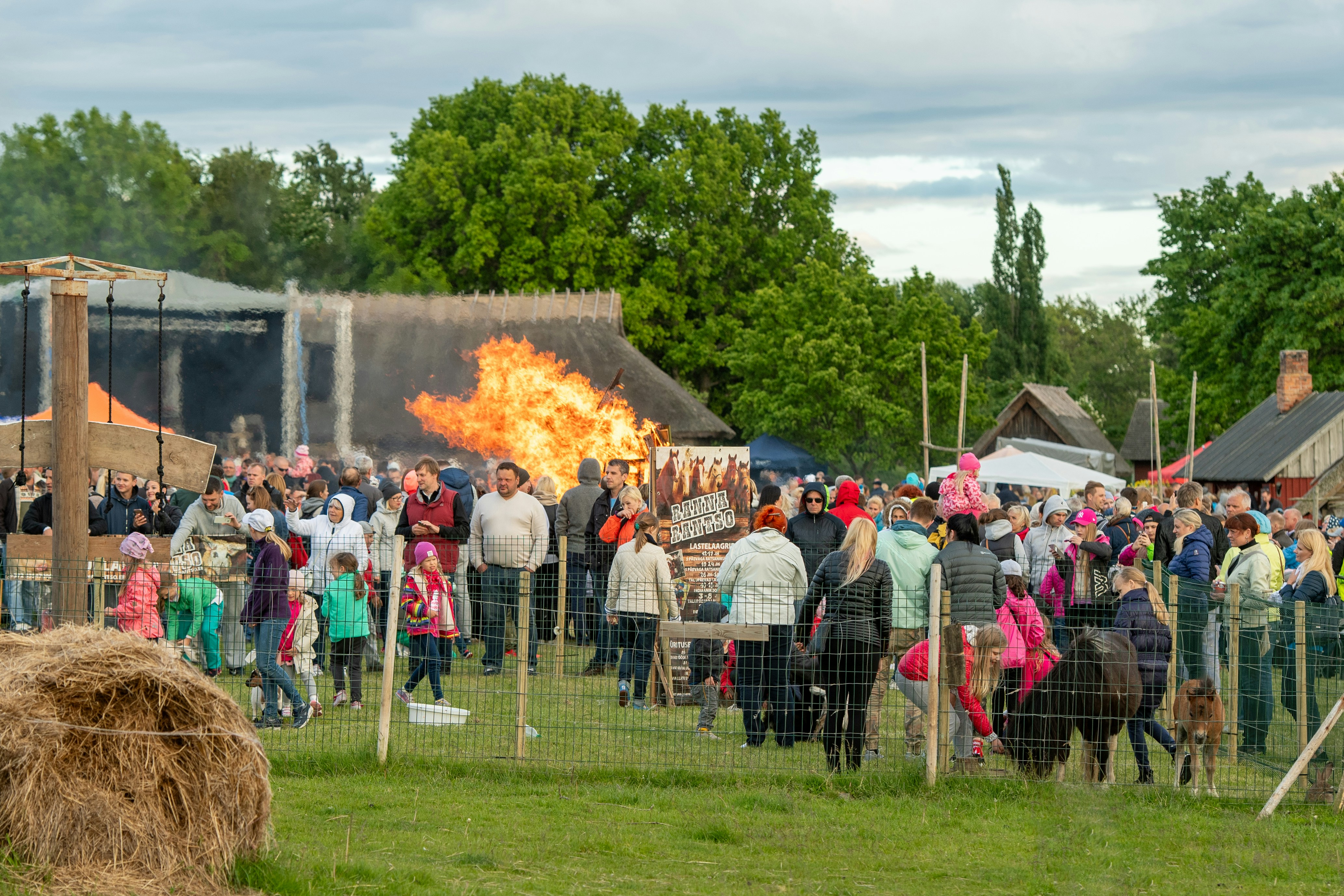 Crowd watches large bonfire at outdoor festival