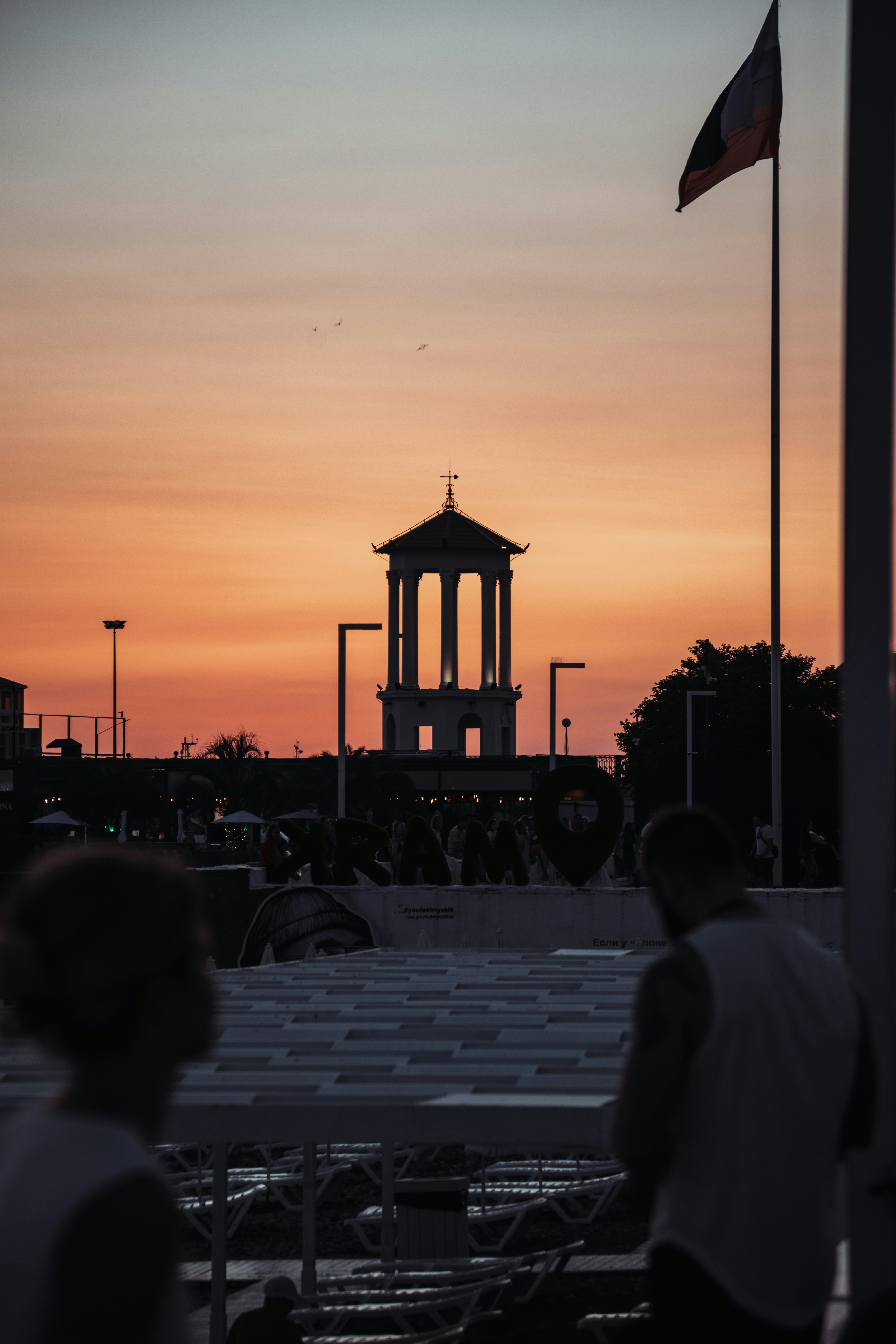 Siluetas clásicas de torre contra un vibrante cielo naranja al atardecer.