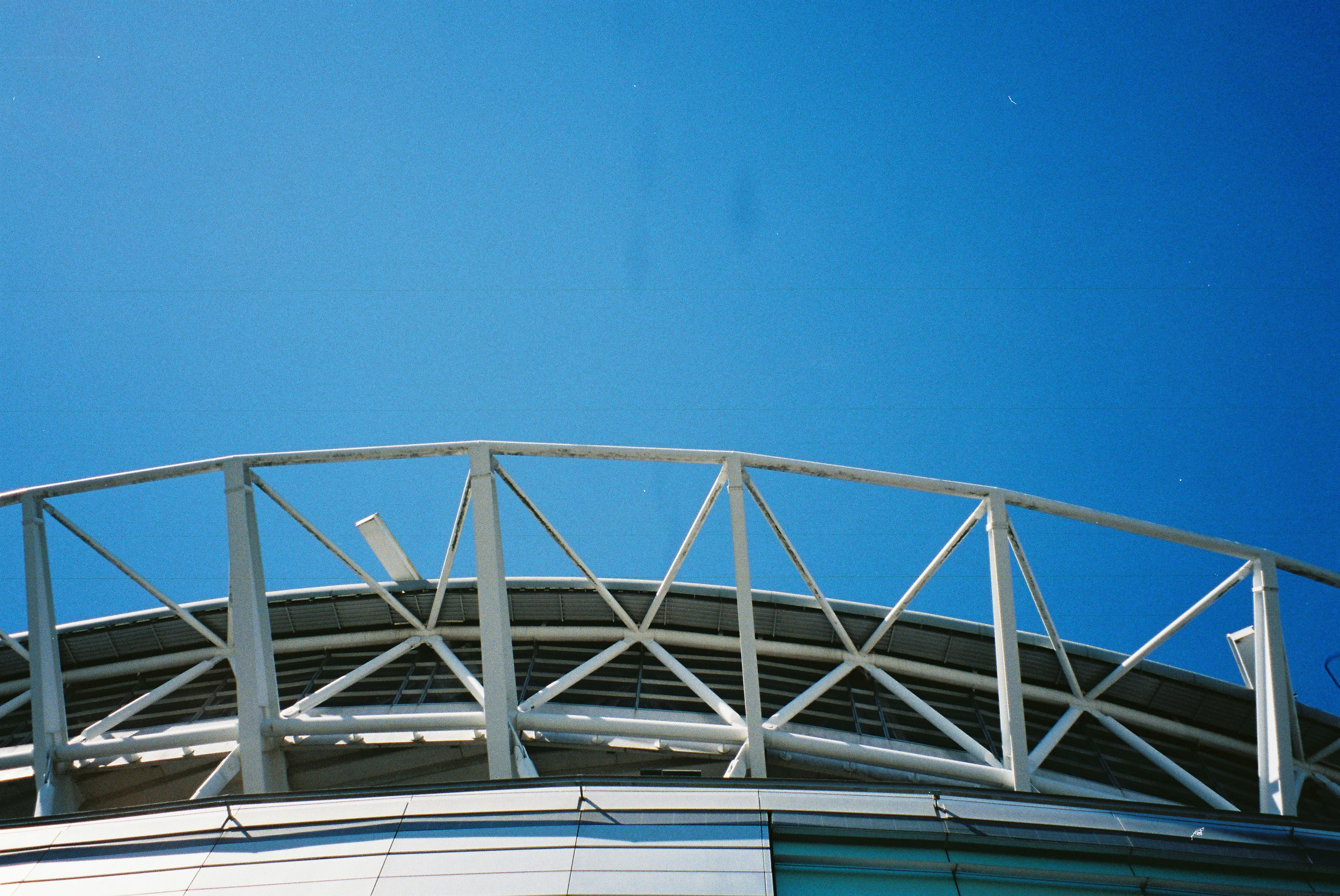 Atap stadion modern dengan langit biru yang cerah