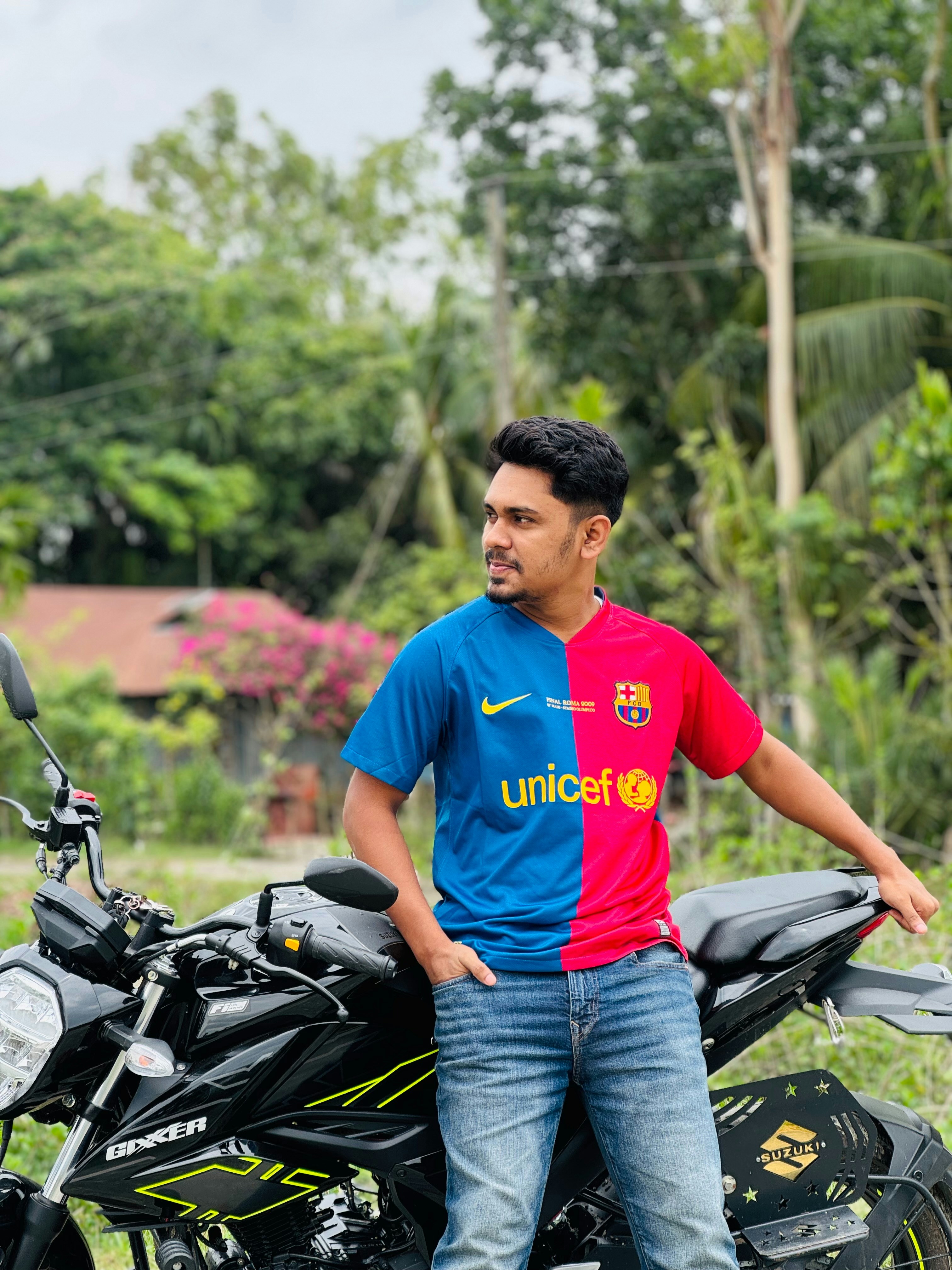 Pria berjersey terpisah bersandar pada sepeda motor di luar ruangan.