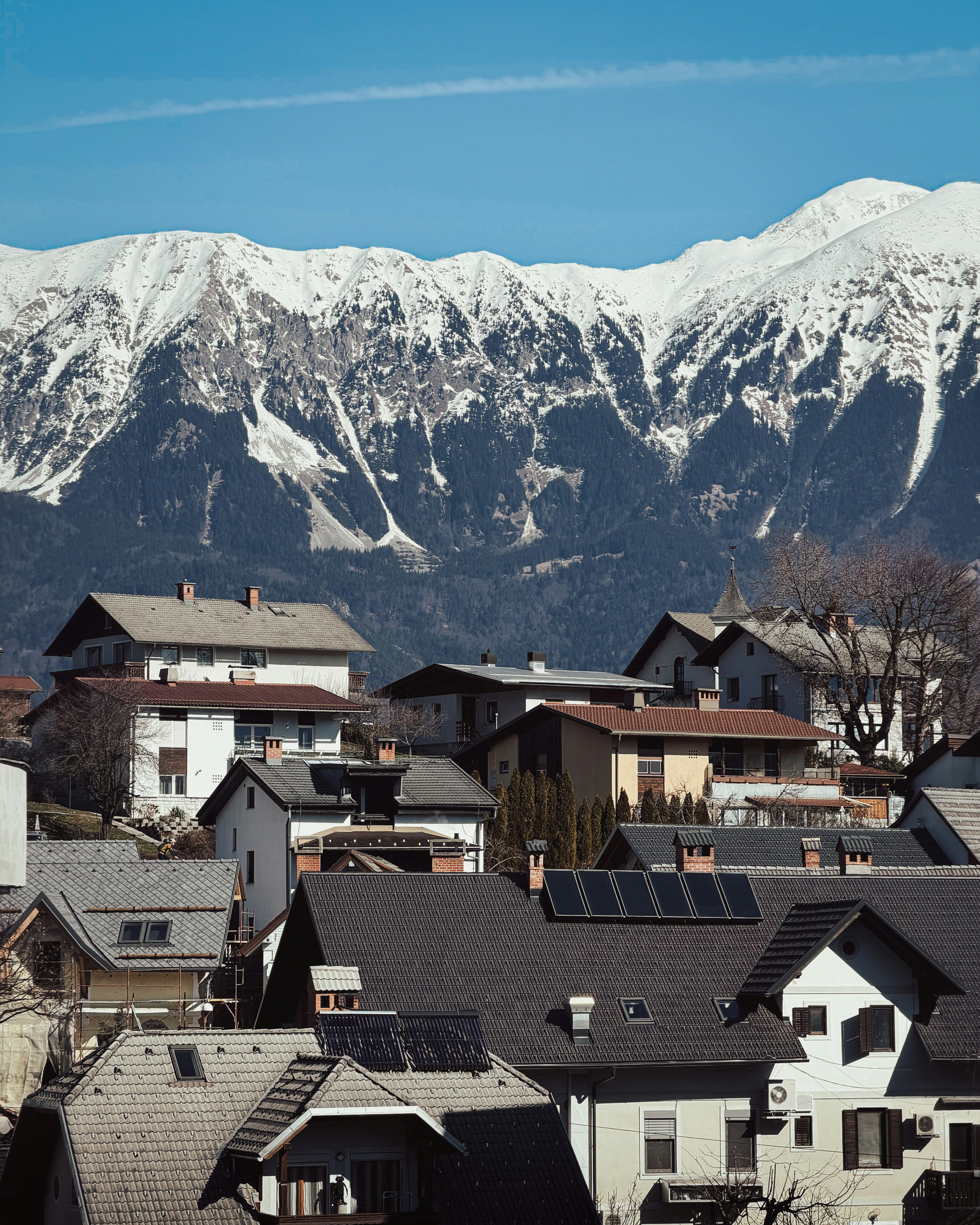 Montagne innevate dominano una città con case.