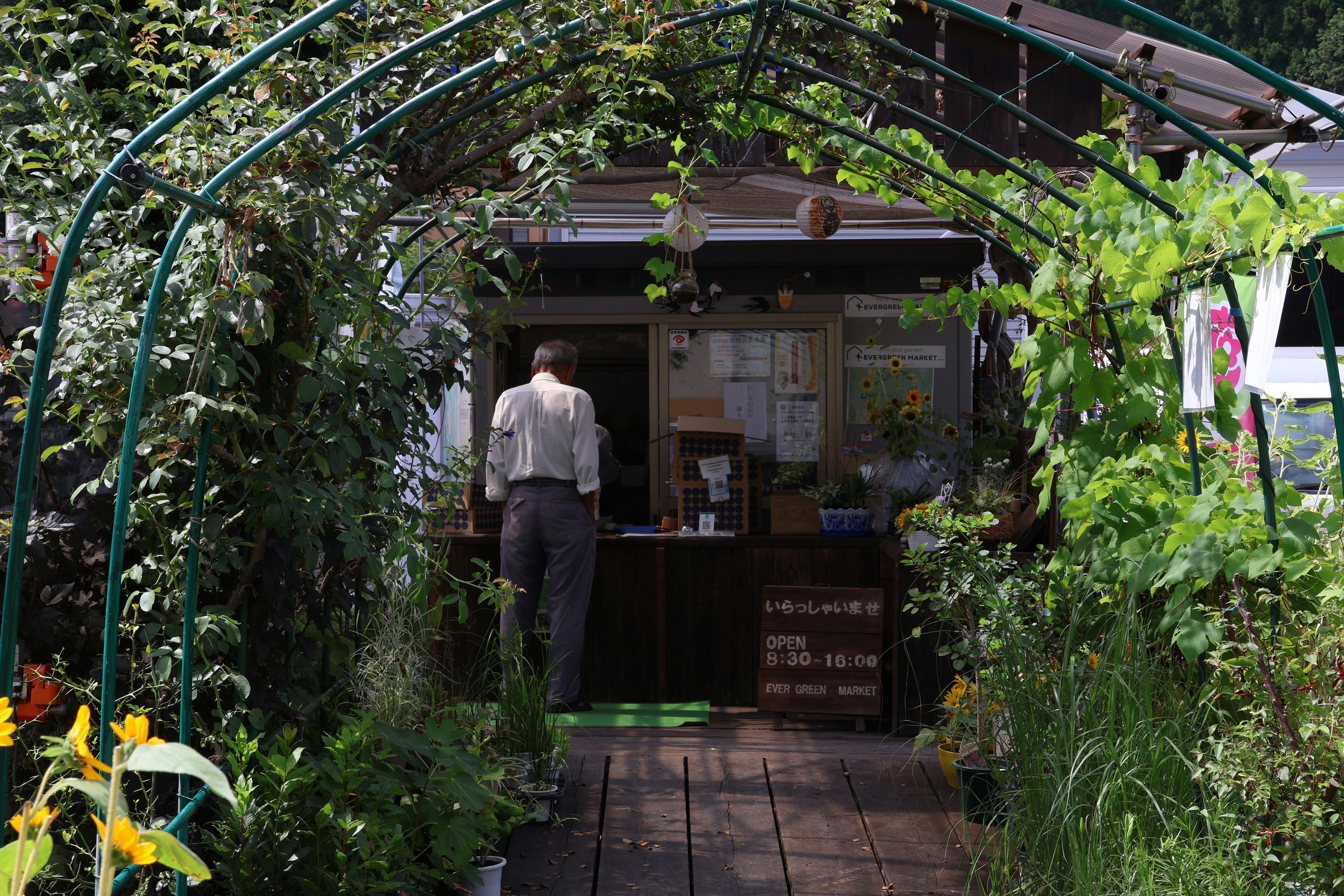 Man enters a shop through a green archway