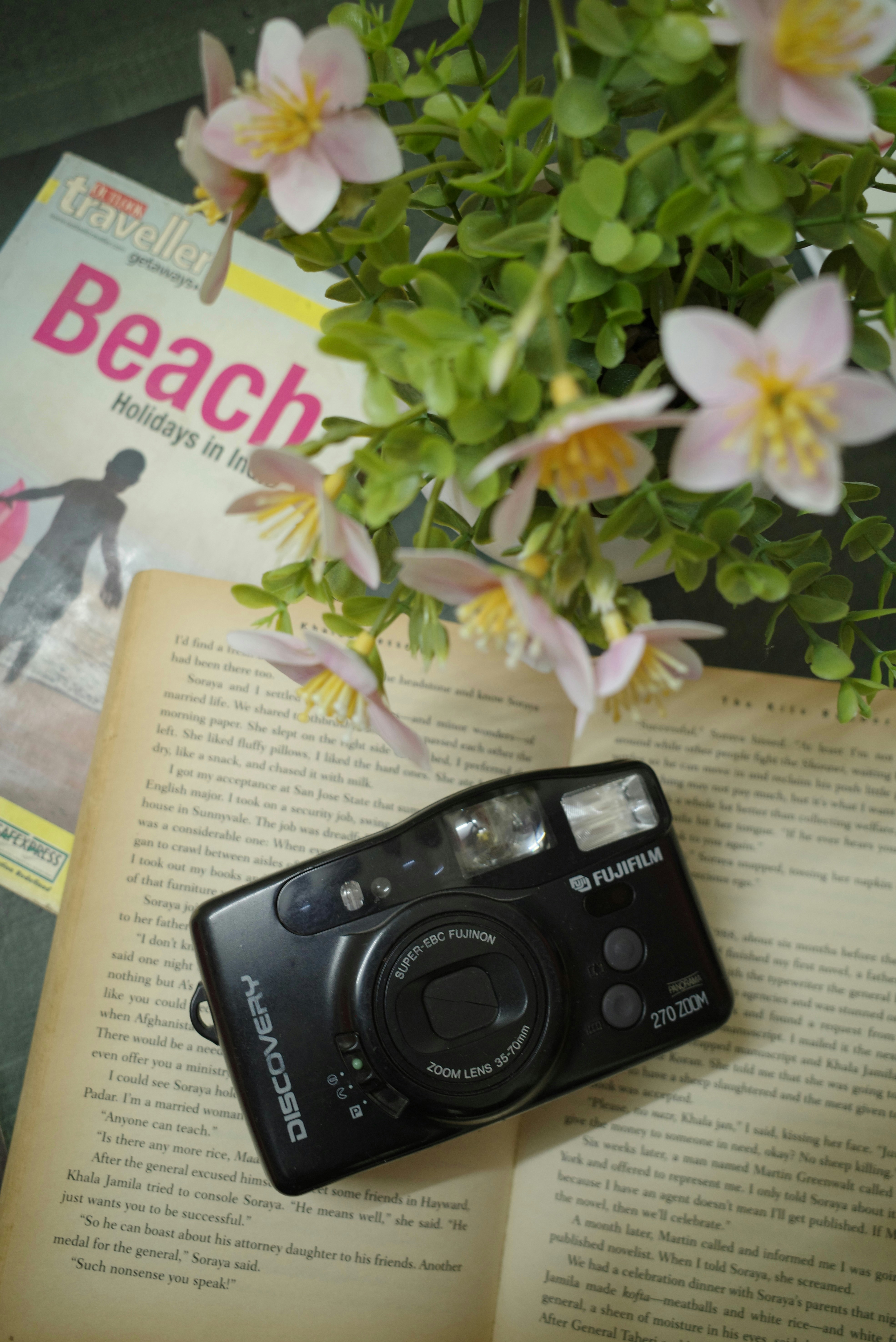 Camera on an open book with flowers and magazine