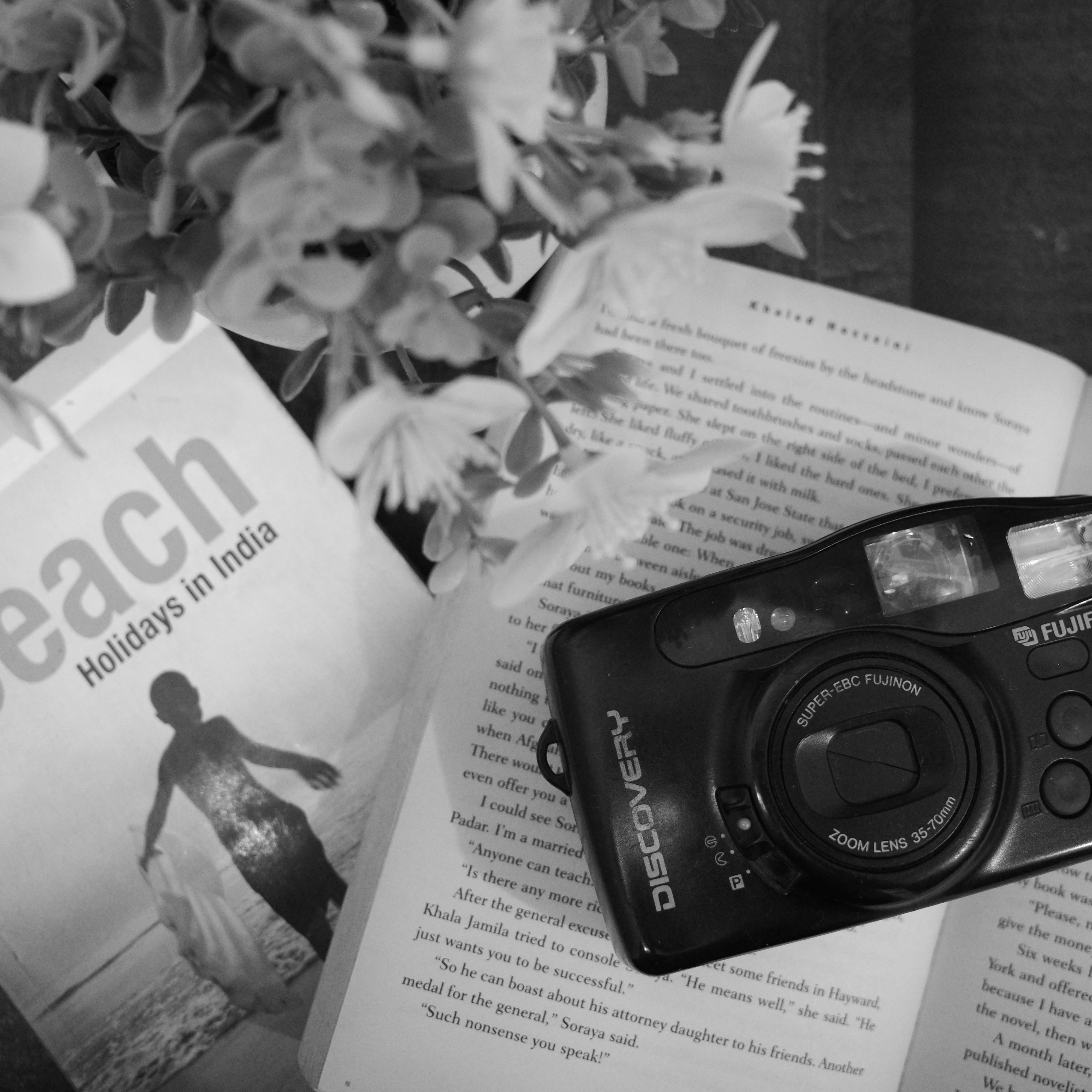 Open books and a camera with flowers