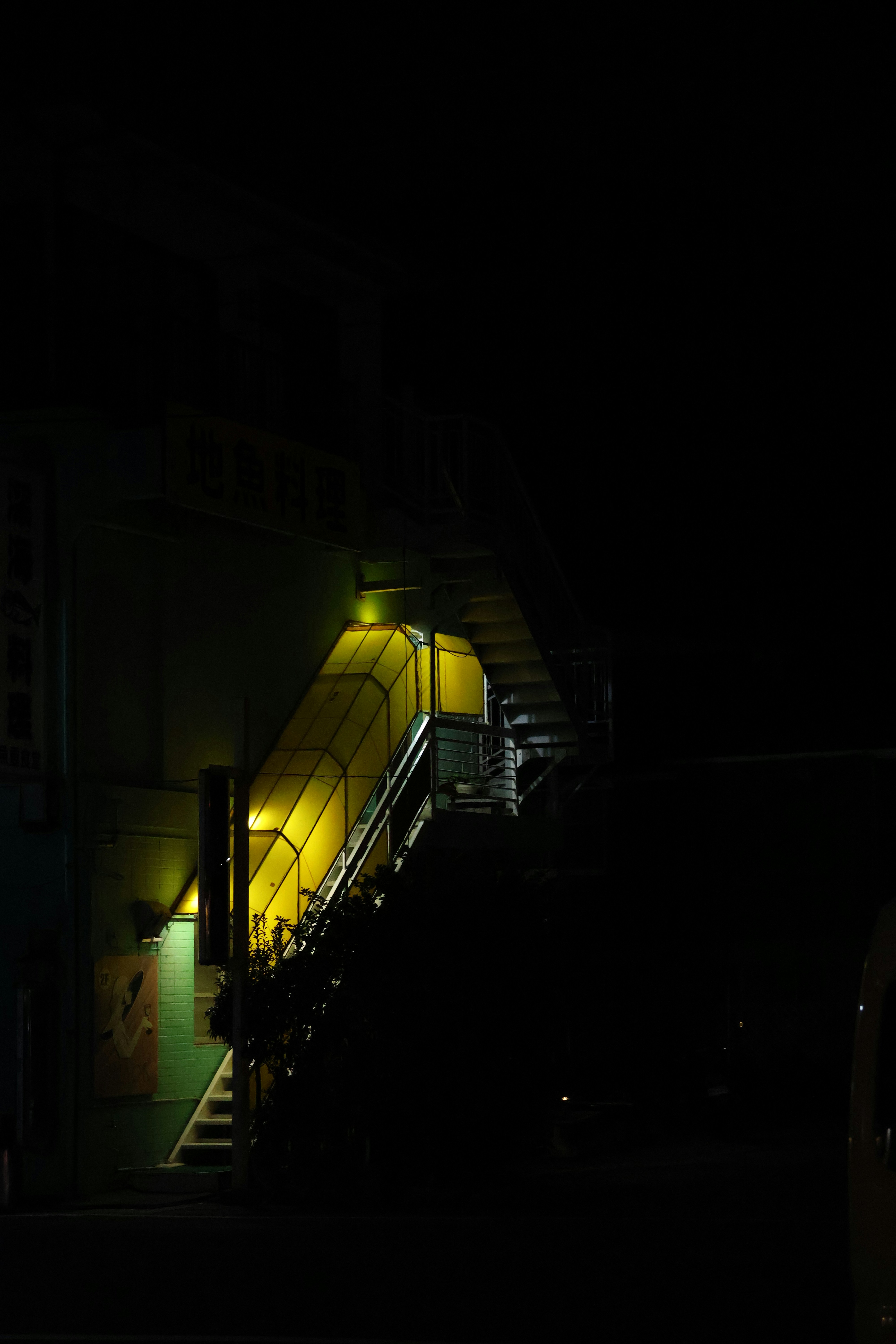 Illuminated stairway at night with dark surroundings