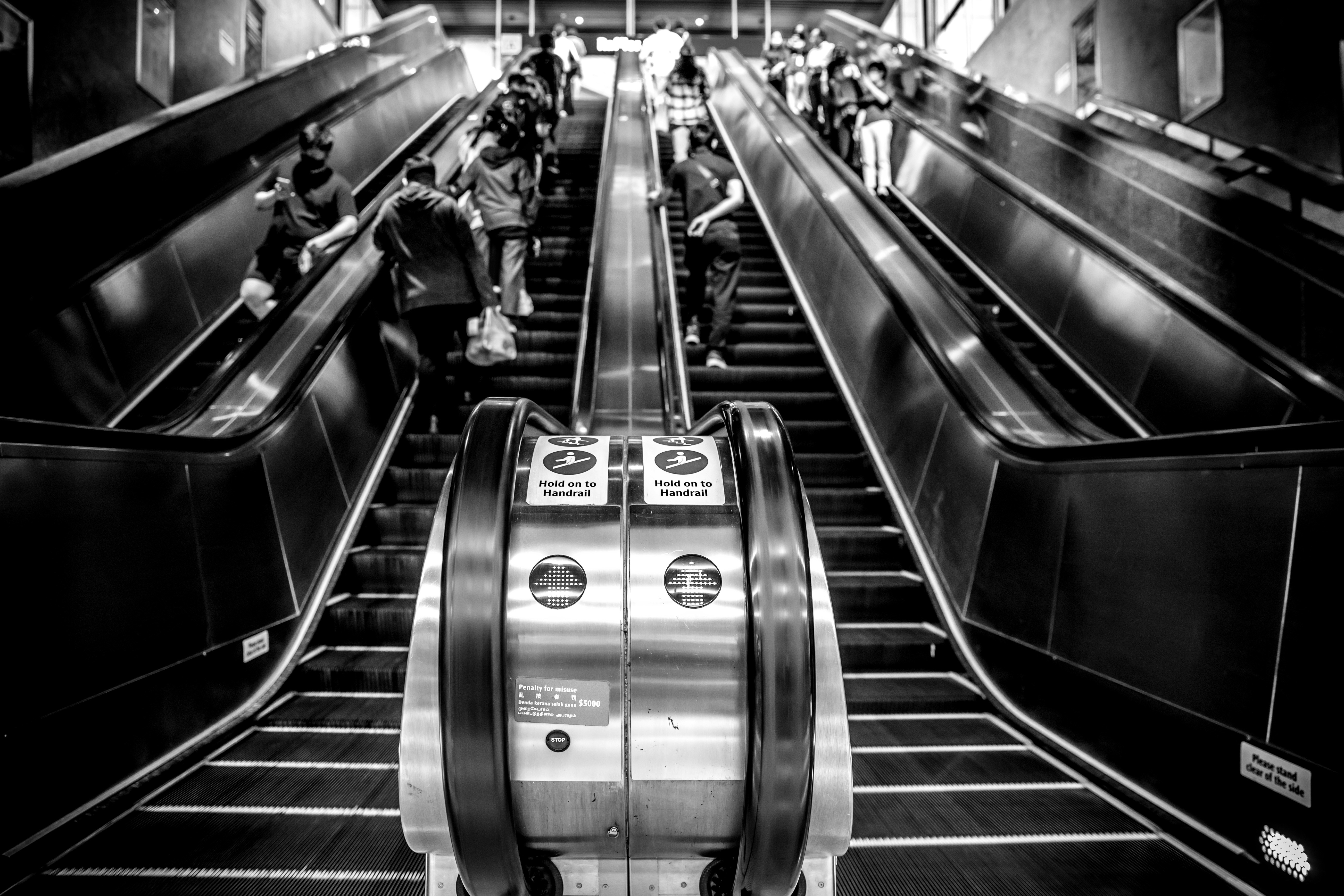 Pessoas andando em escadas rolantes em uma estação de metrô.