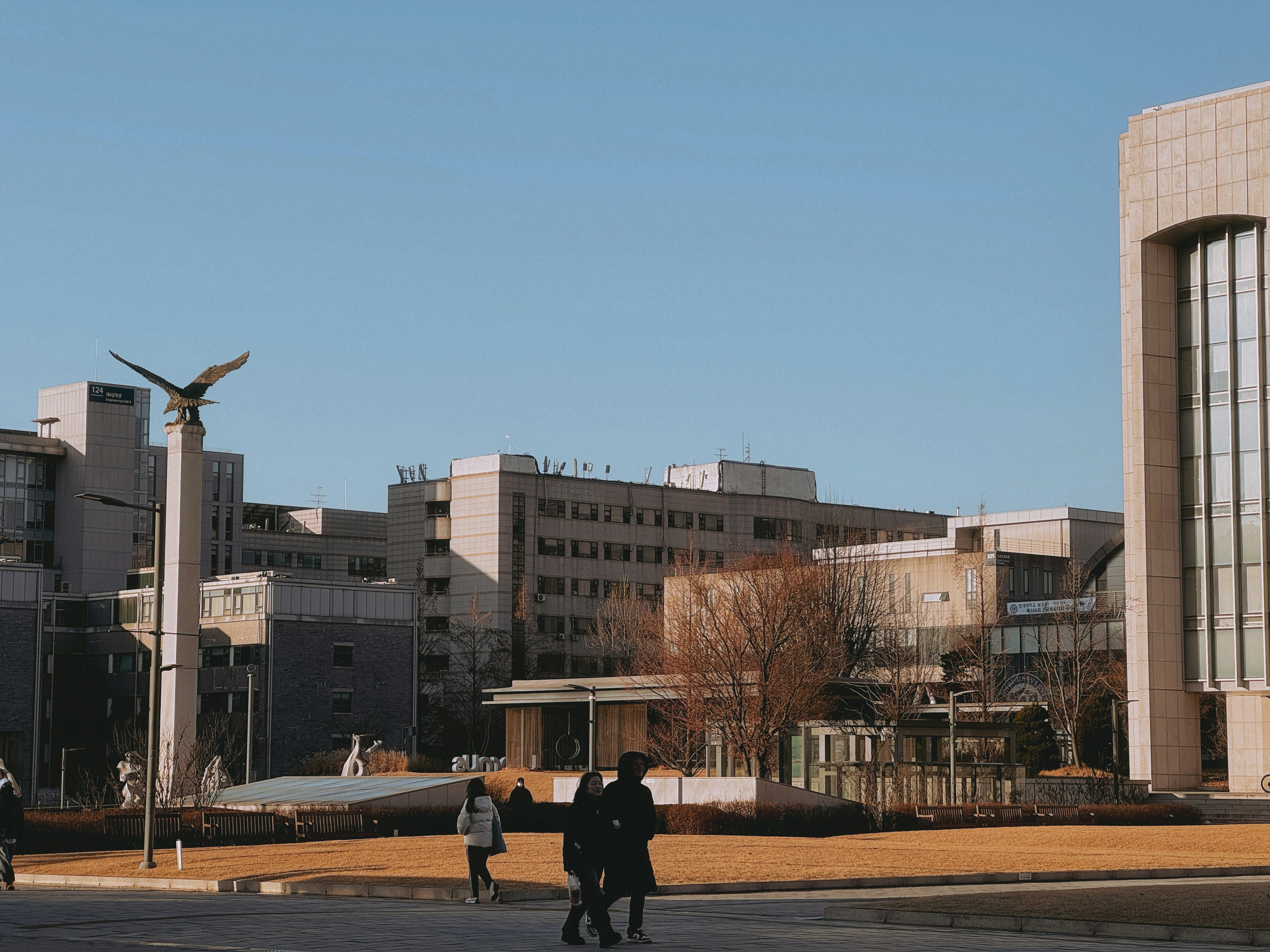 People walking on a college campus with modern buildings
