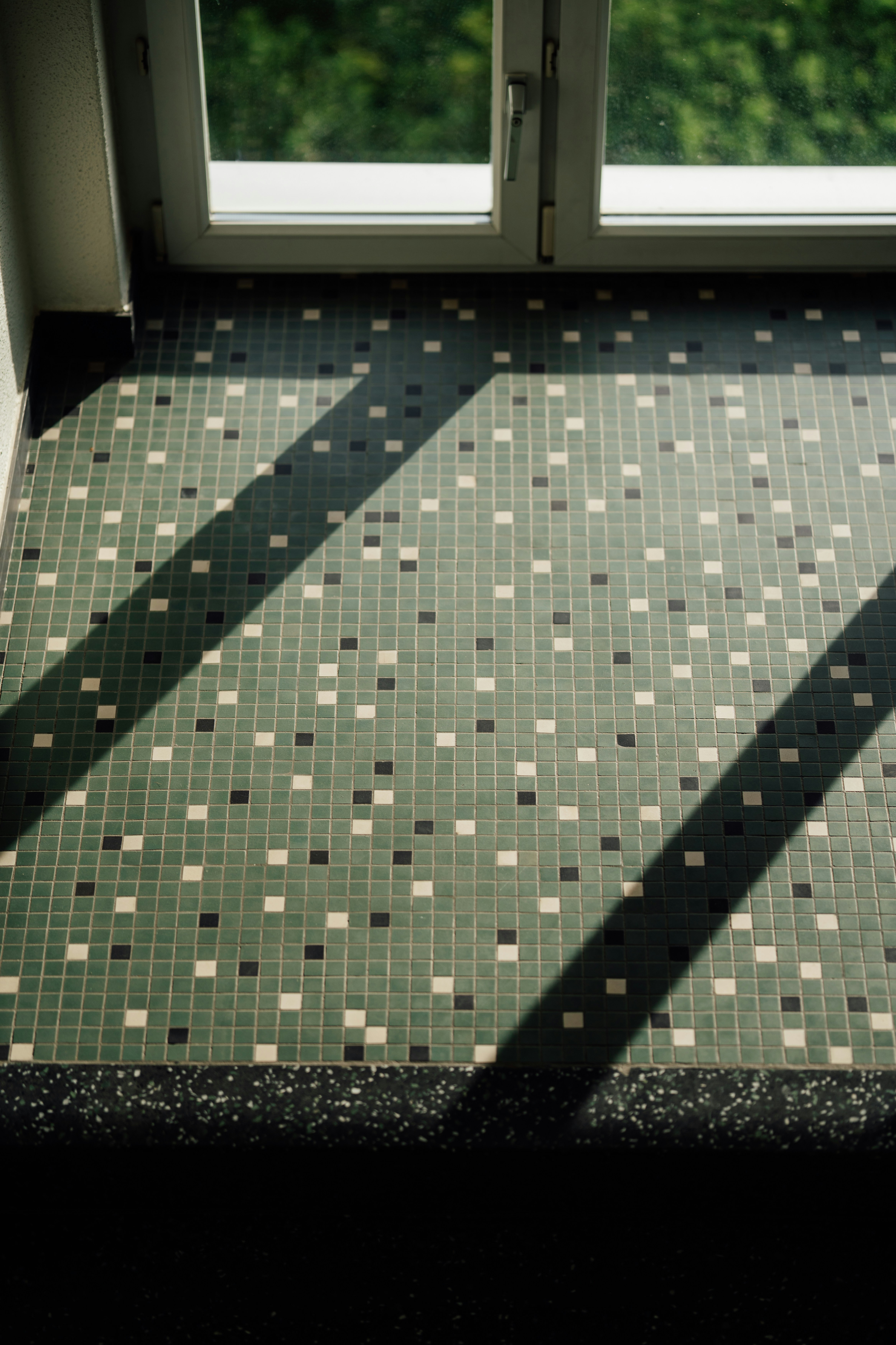 Sunlight streaming across a tiled floor by window