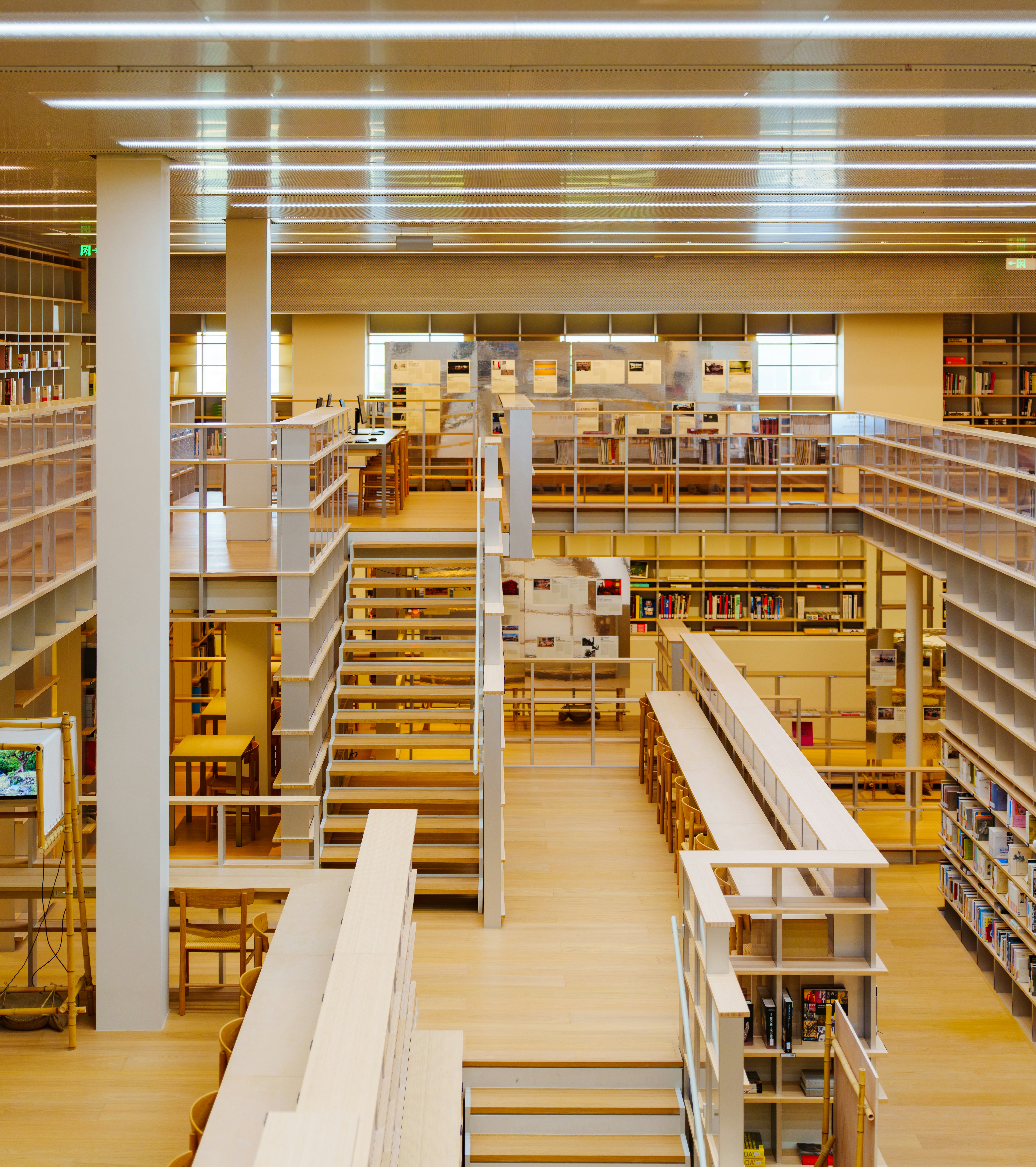 Modern library interior with multi-level bookshelves and stairs