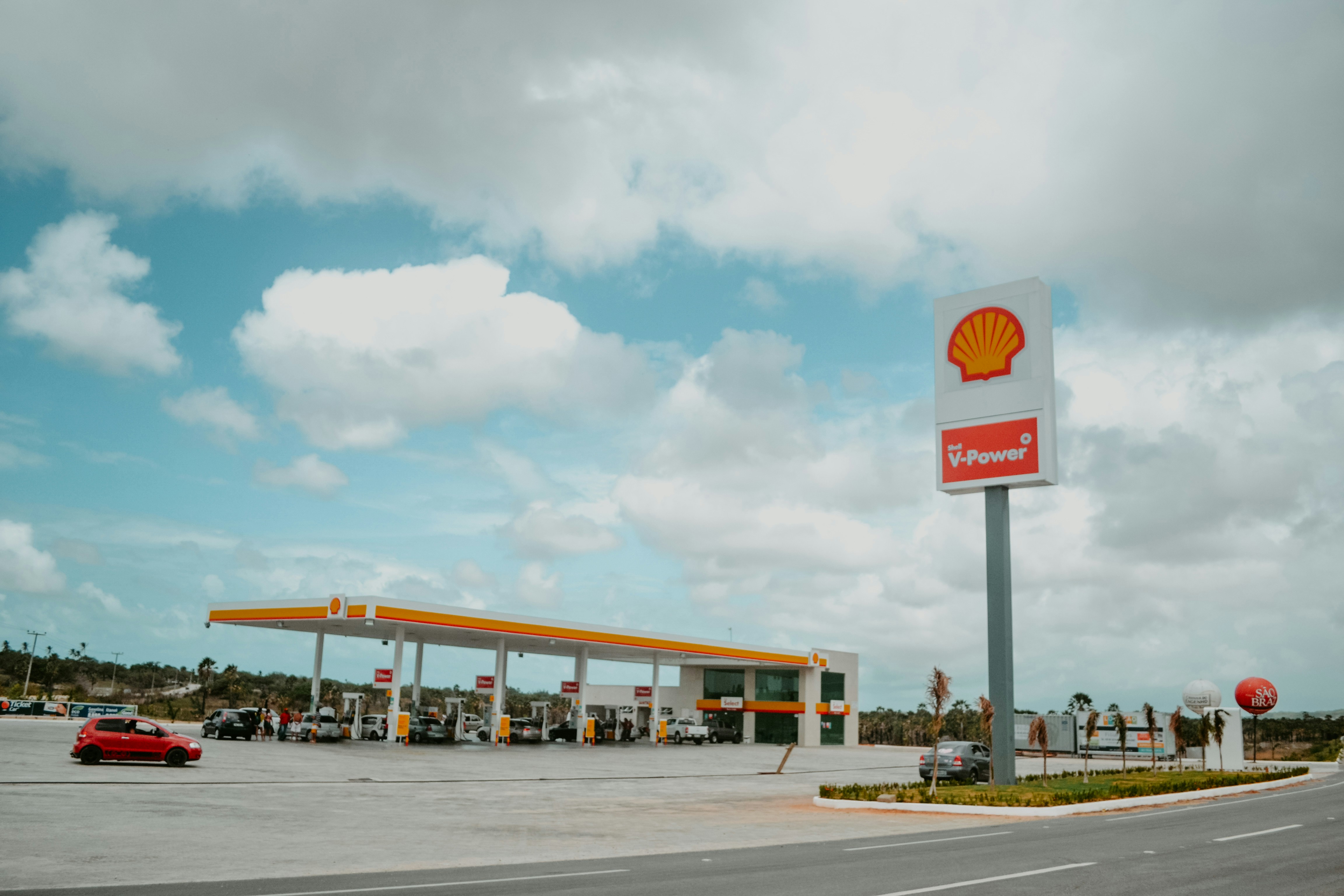 Station-service Shell sous un ciel bleu nuageux