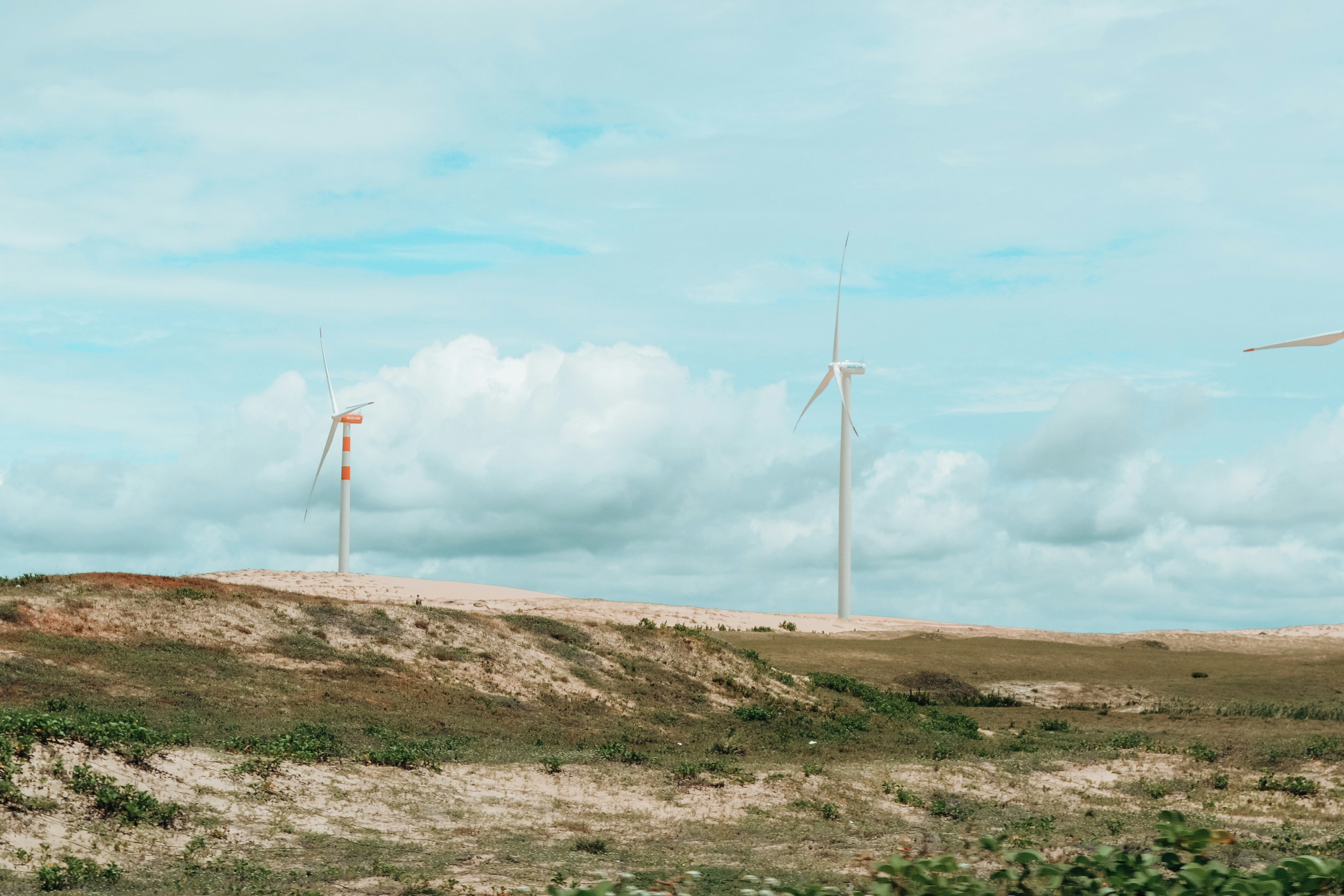 Éoliennes sur une colline herbeuse sous un ciel nuageux