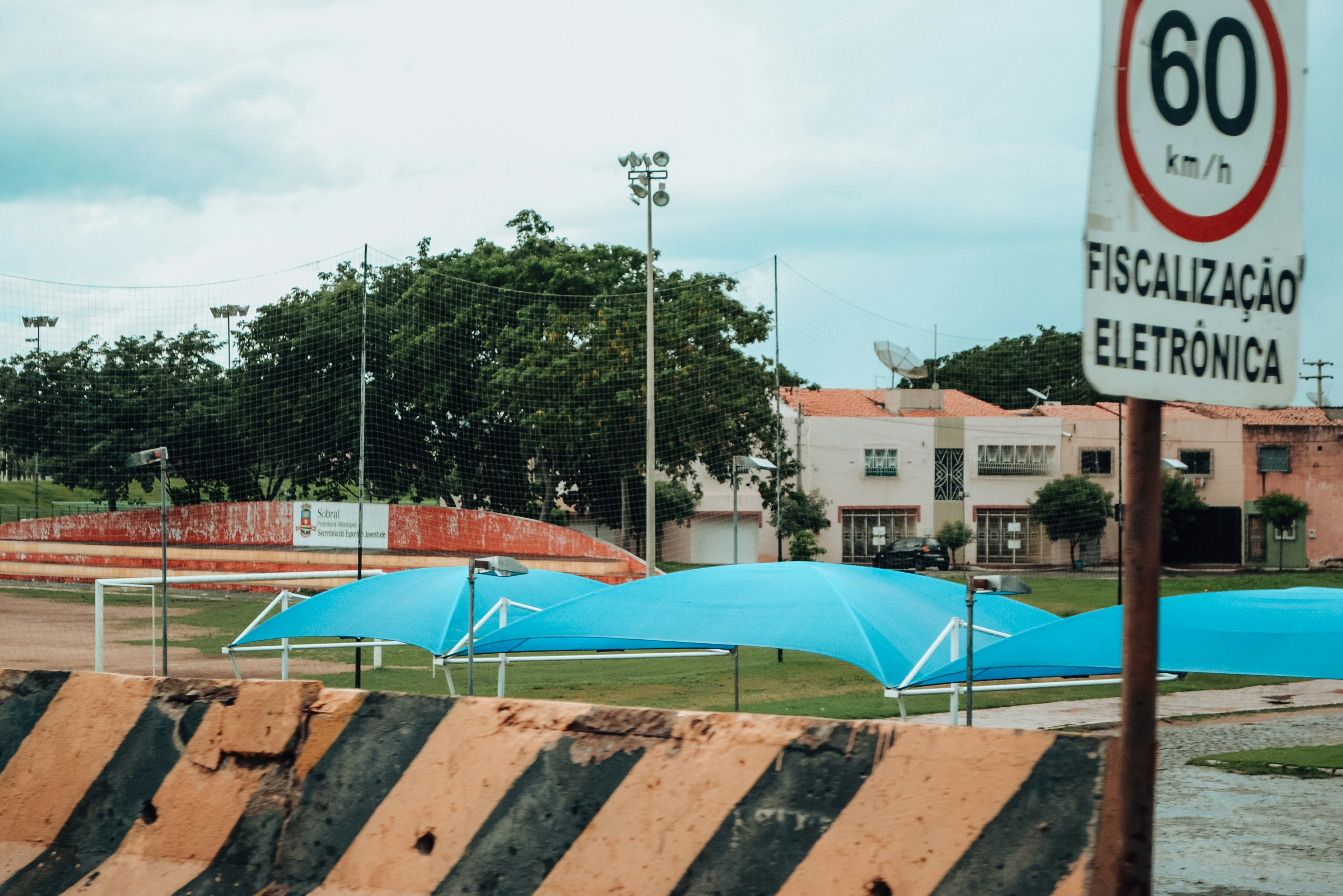 Blue inflatable structures on grassy field near buildings