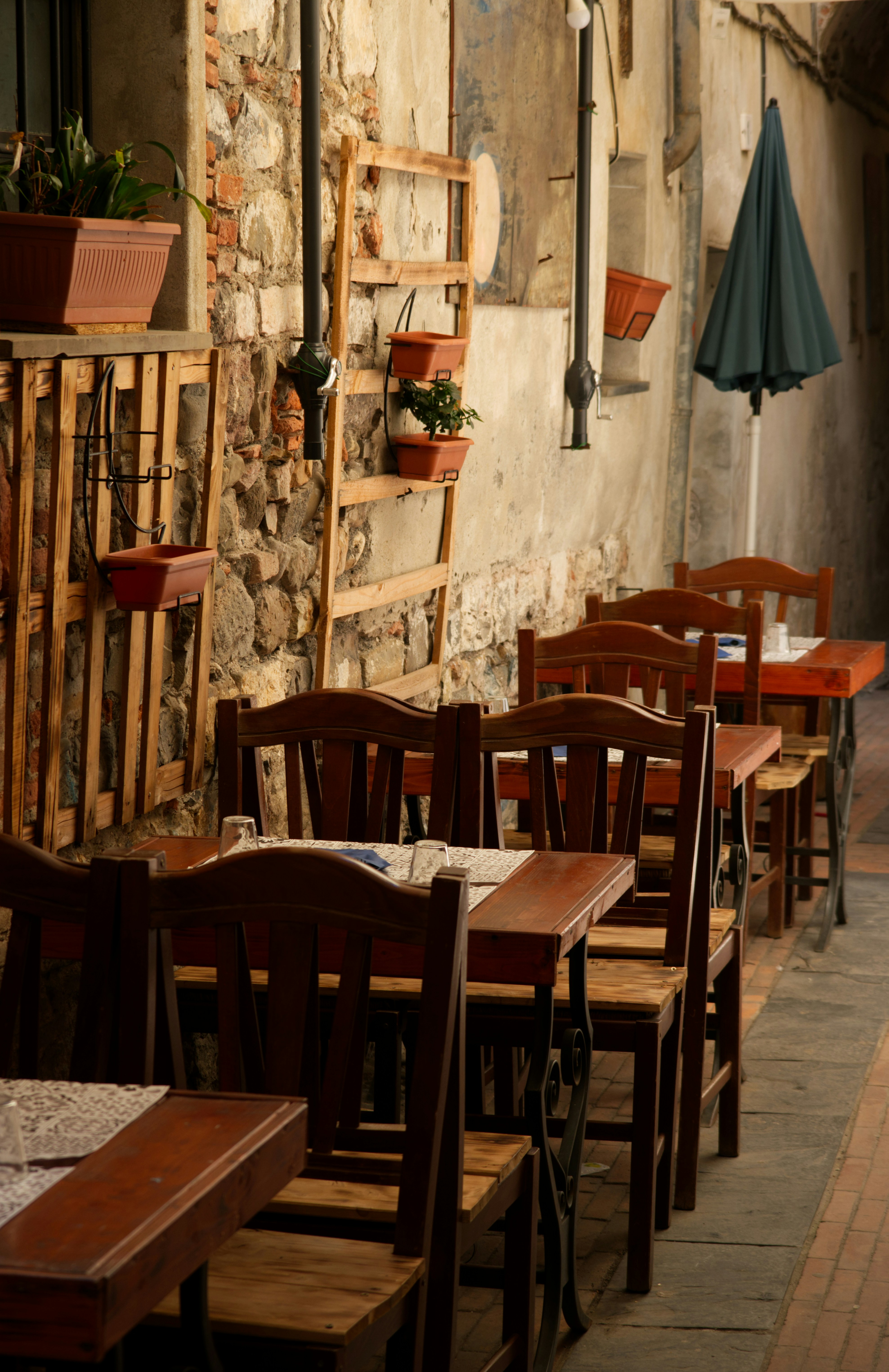 Cafétische und -stühle im Freien mit Pflanzen