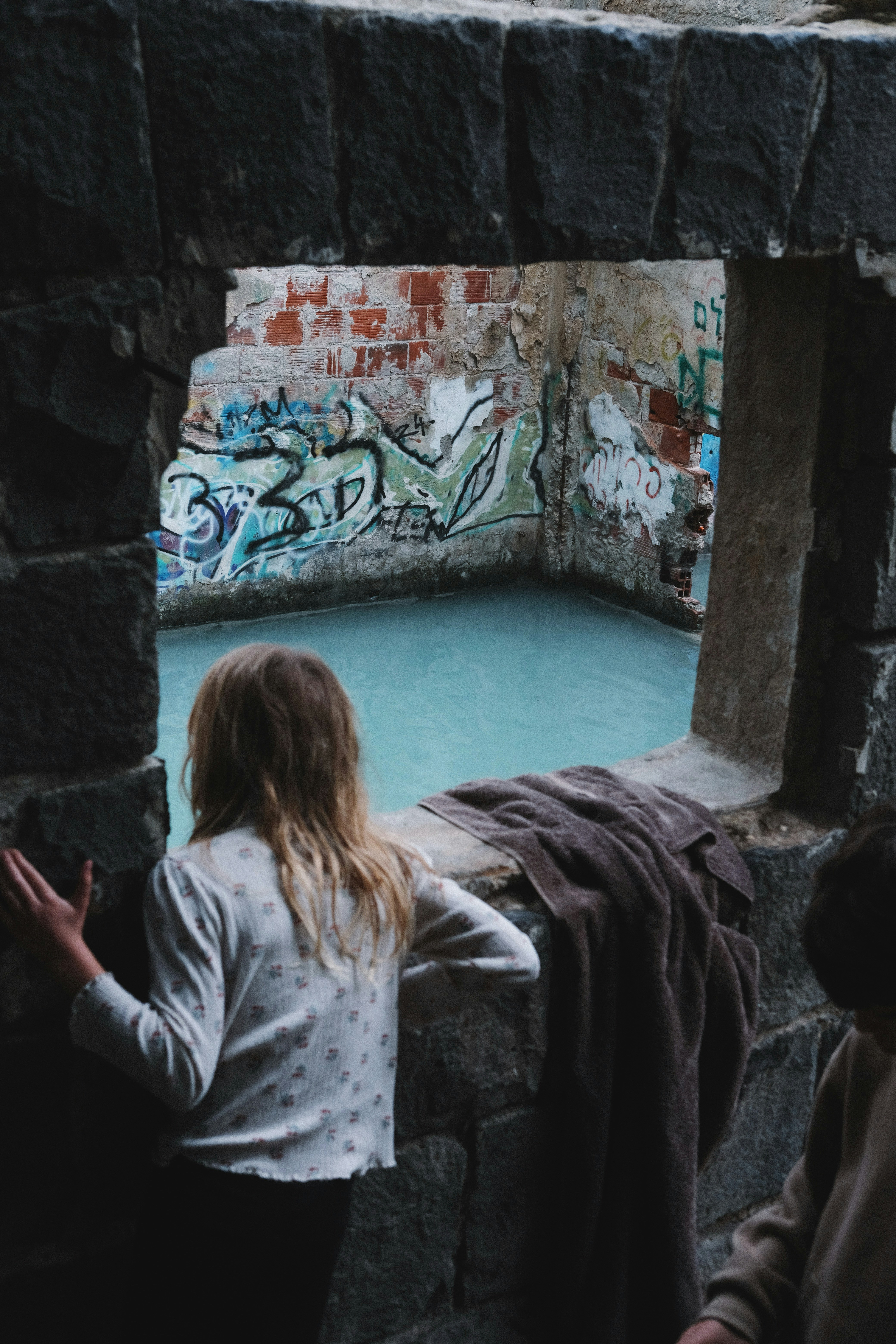 Children looking at a pool with graffiti walls