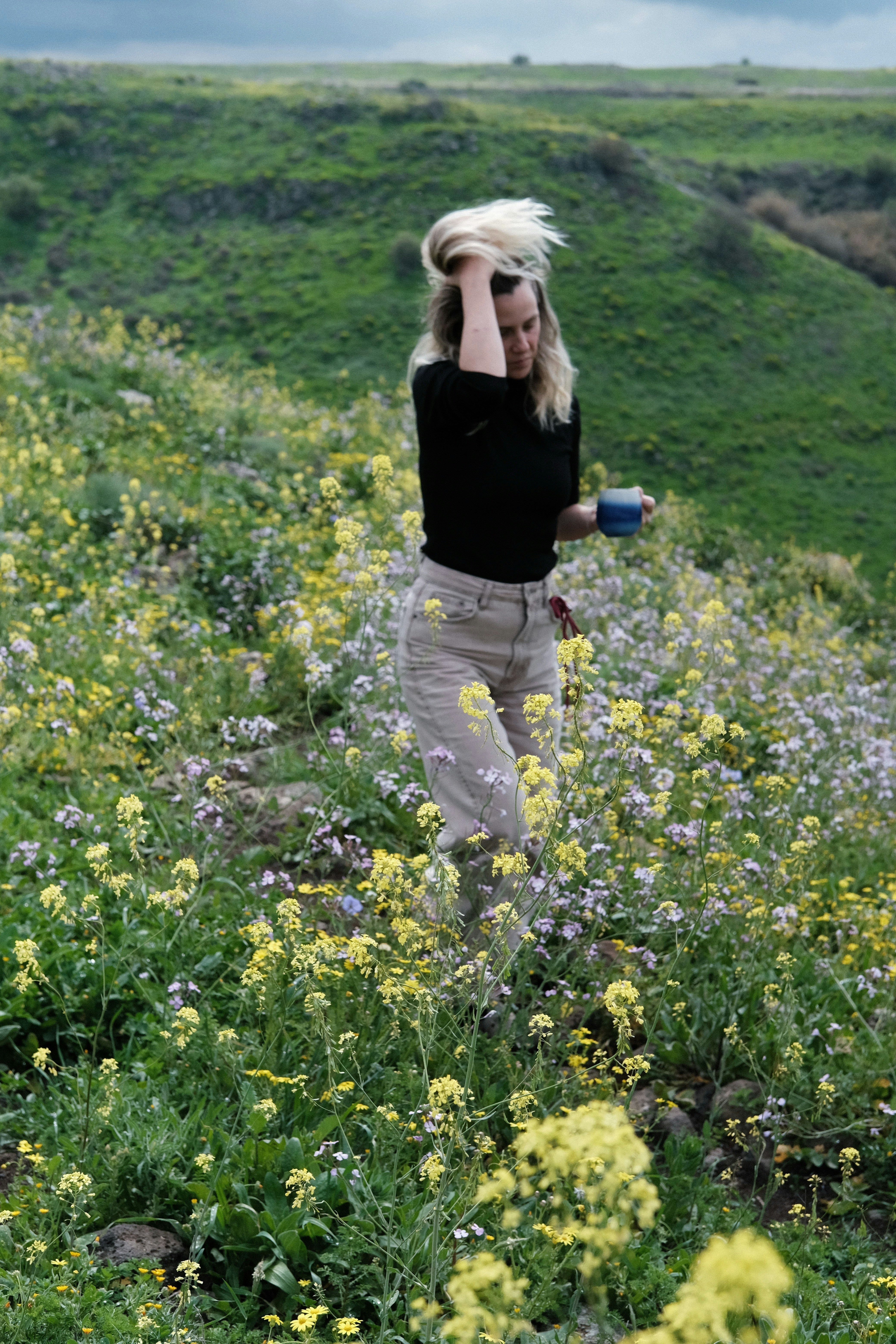 Woman walking through a field of wildflowers
