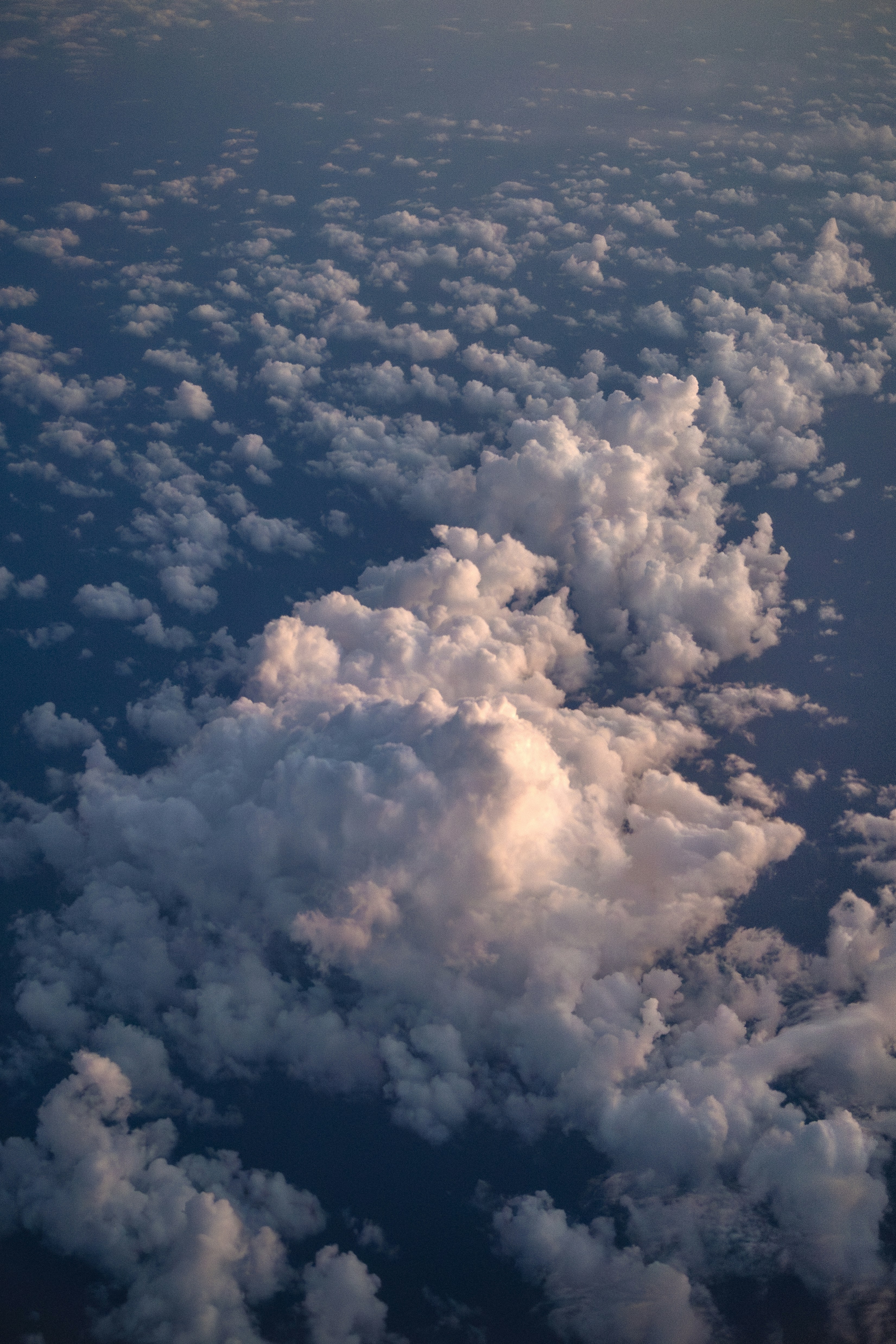 Fluffy white clouds scattered across a dark blue sky.