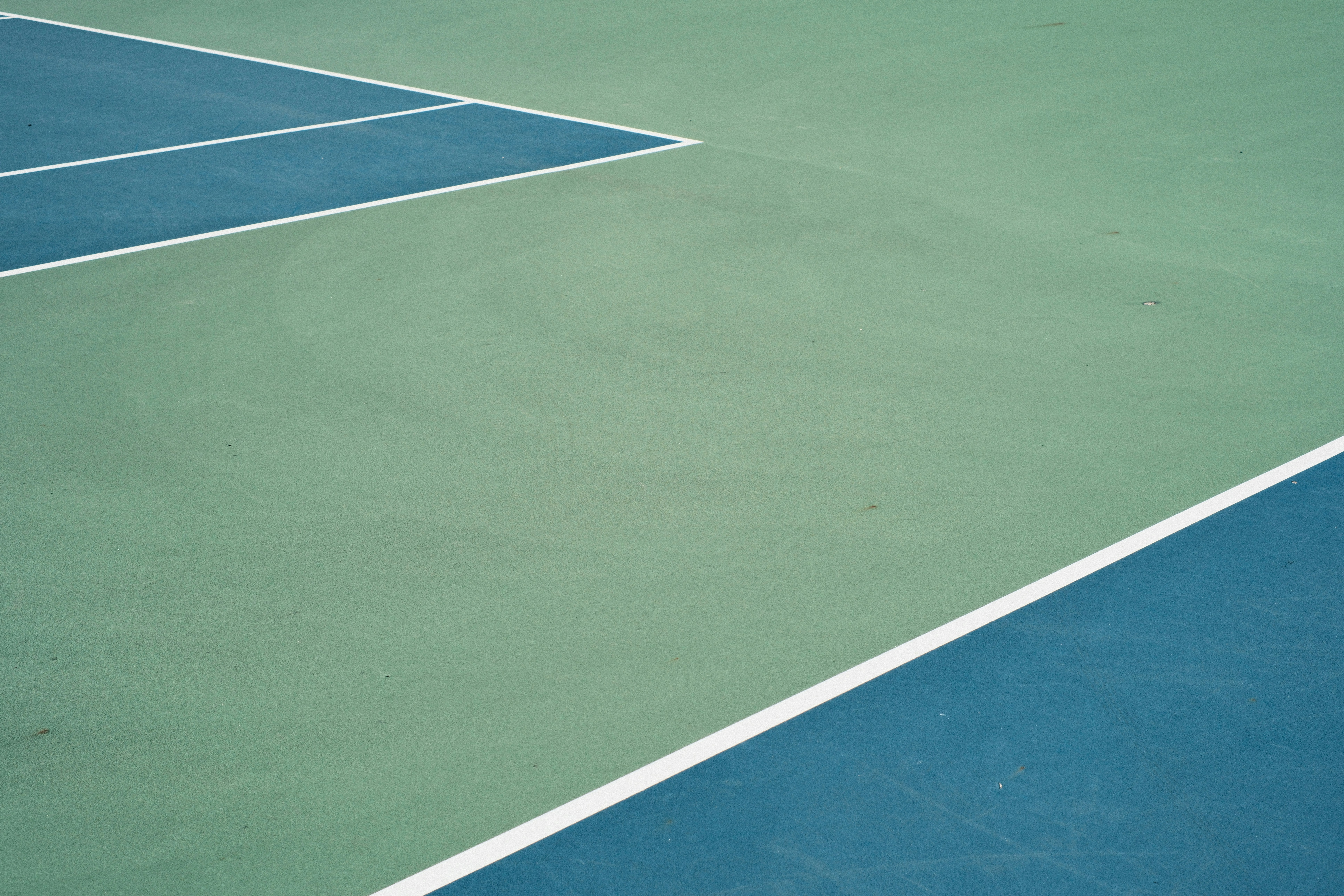 Green and blue tennis court with white lines